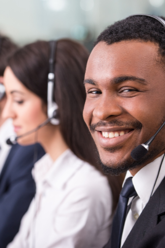 Customer service team members wearing headsets, working at a call center.
