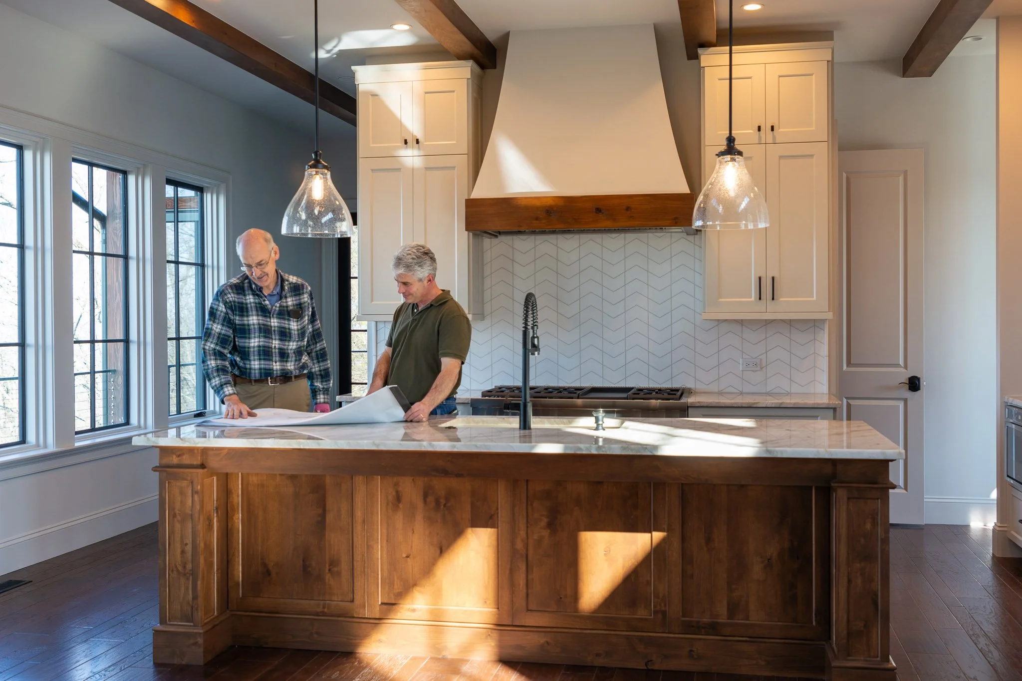 Kevin Dolab reviewing luxury home architectural plans inside a custom kitchen build in Asheville.⁠