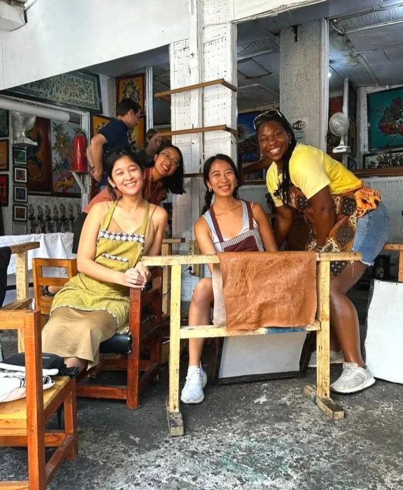 Four women smiling and posing at a restaurant or cafe.