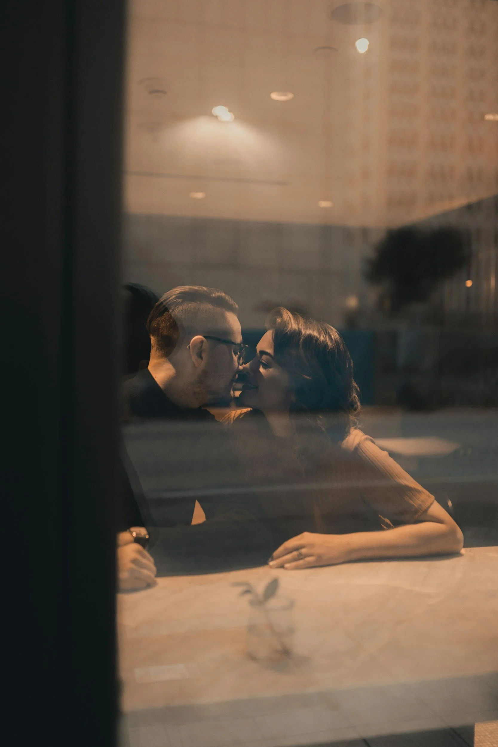Couple leaning in during meaningful conversation about their relationship at a cafe