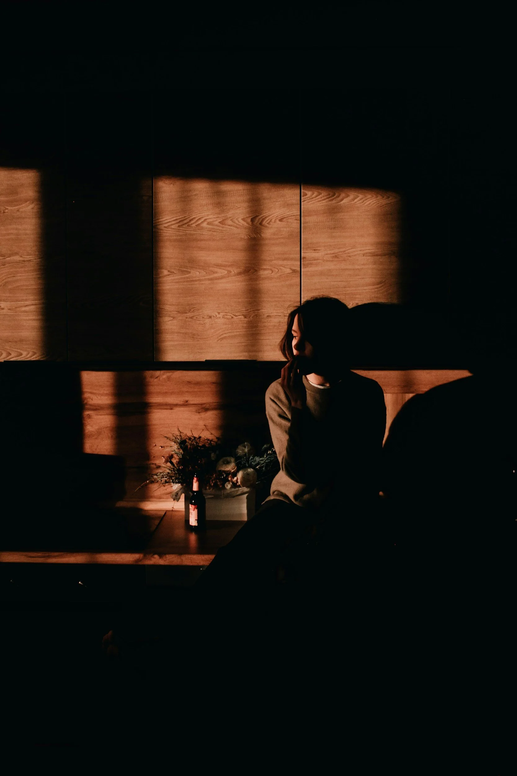 Woman in stillness with light and shadow, capturing a nuanced moment of reflection and self awareness