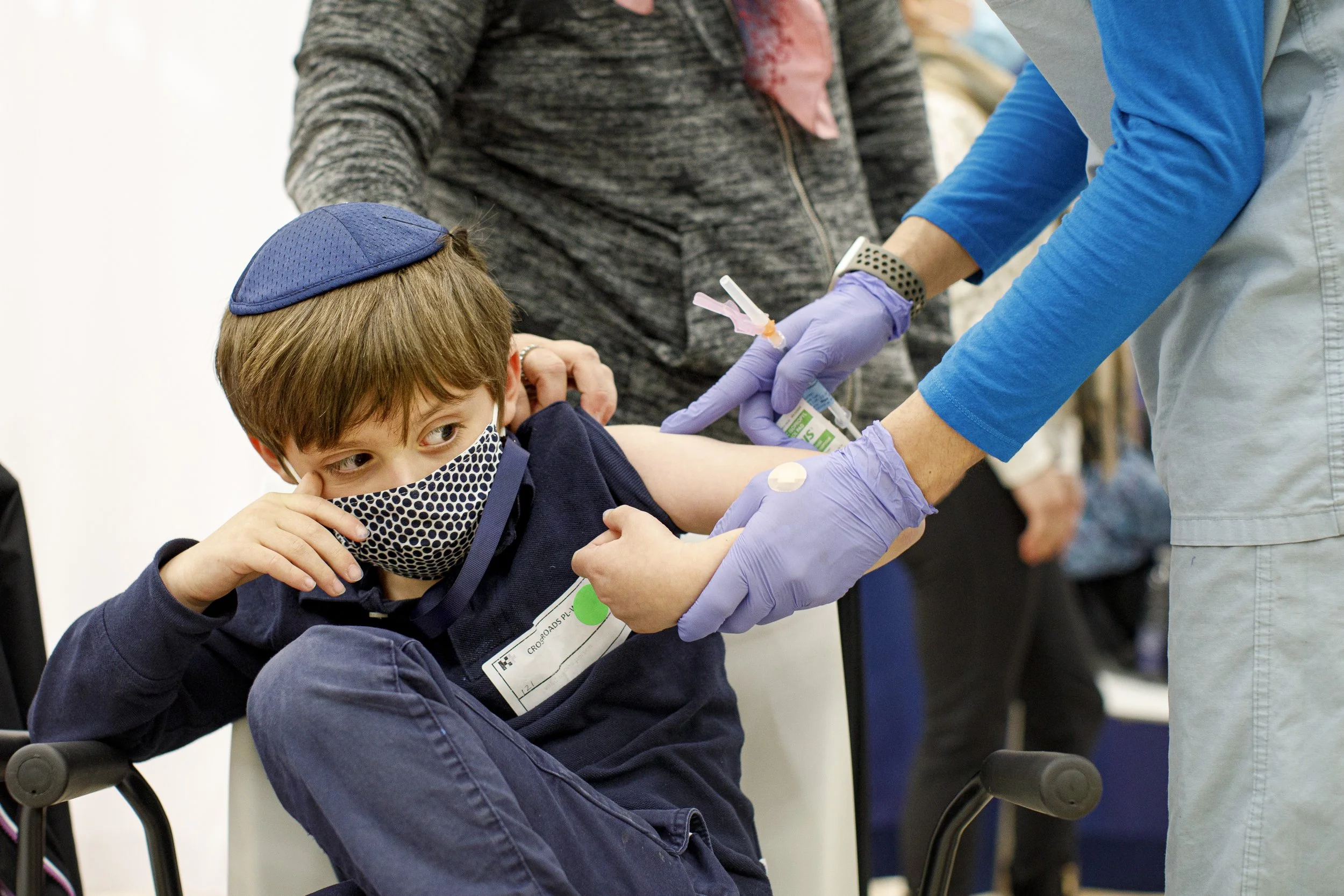 Eli Stern, with his mother Hyla Robicsek’s hand on his shoulder, receives a dose of COVID-19 vaccine at a clinic in North York on Nov. 25, 2021.