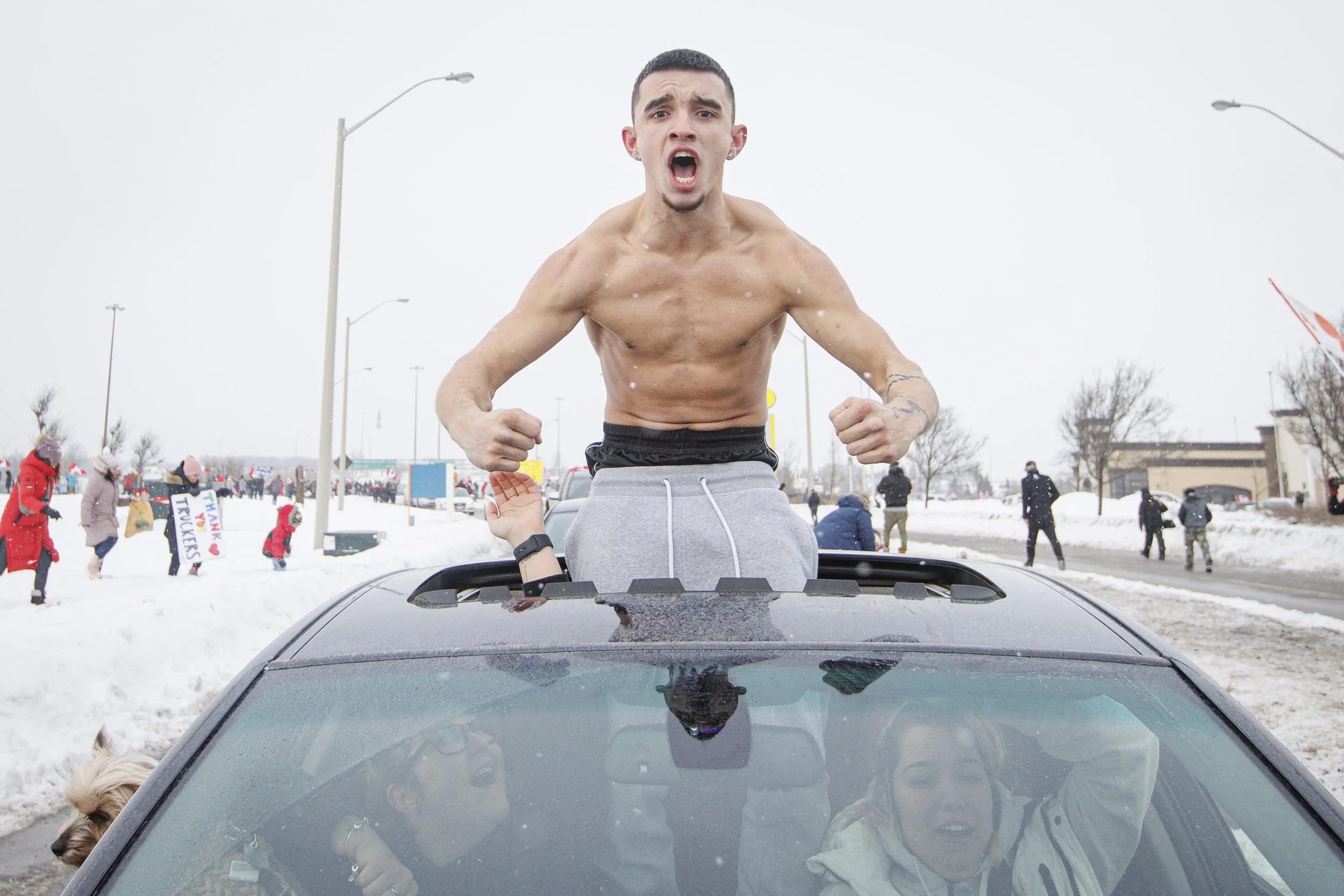 Supporters of an anti-vaccine mandate convoy bound for Ottawa cheer on a line of truckers as they pass Vaughn Mills outlet mall, in Vaughn, Ont., on Jan. 27, 2022.