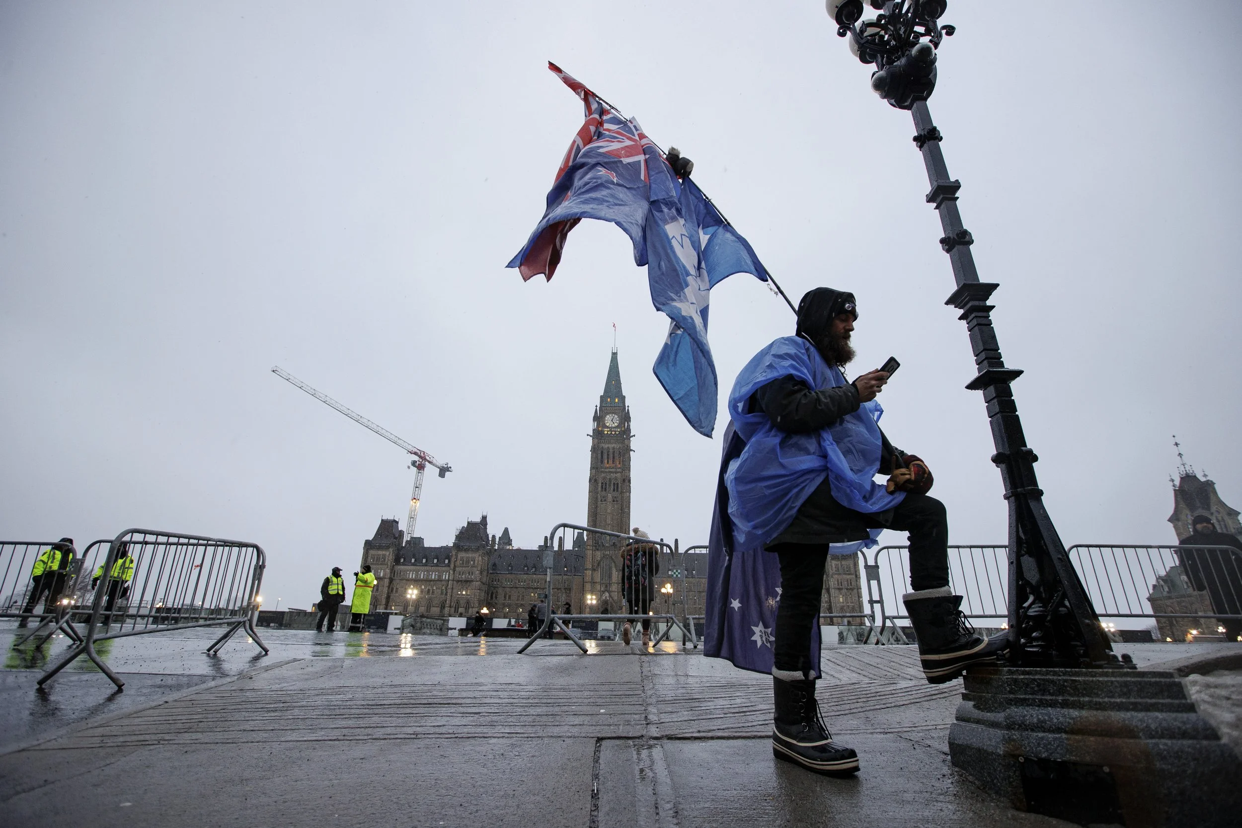 An protest attendee with a tattered colonial flag is pictured in front of Parliament Hill, in Ottawa, on Feb. 17, 2022.