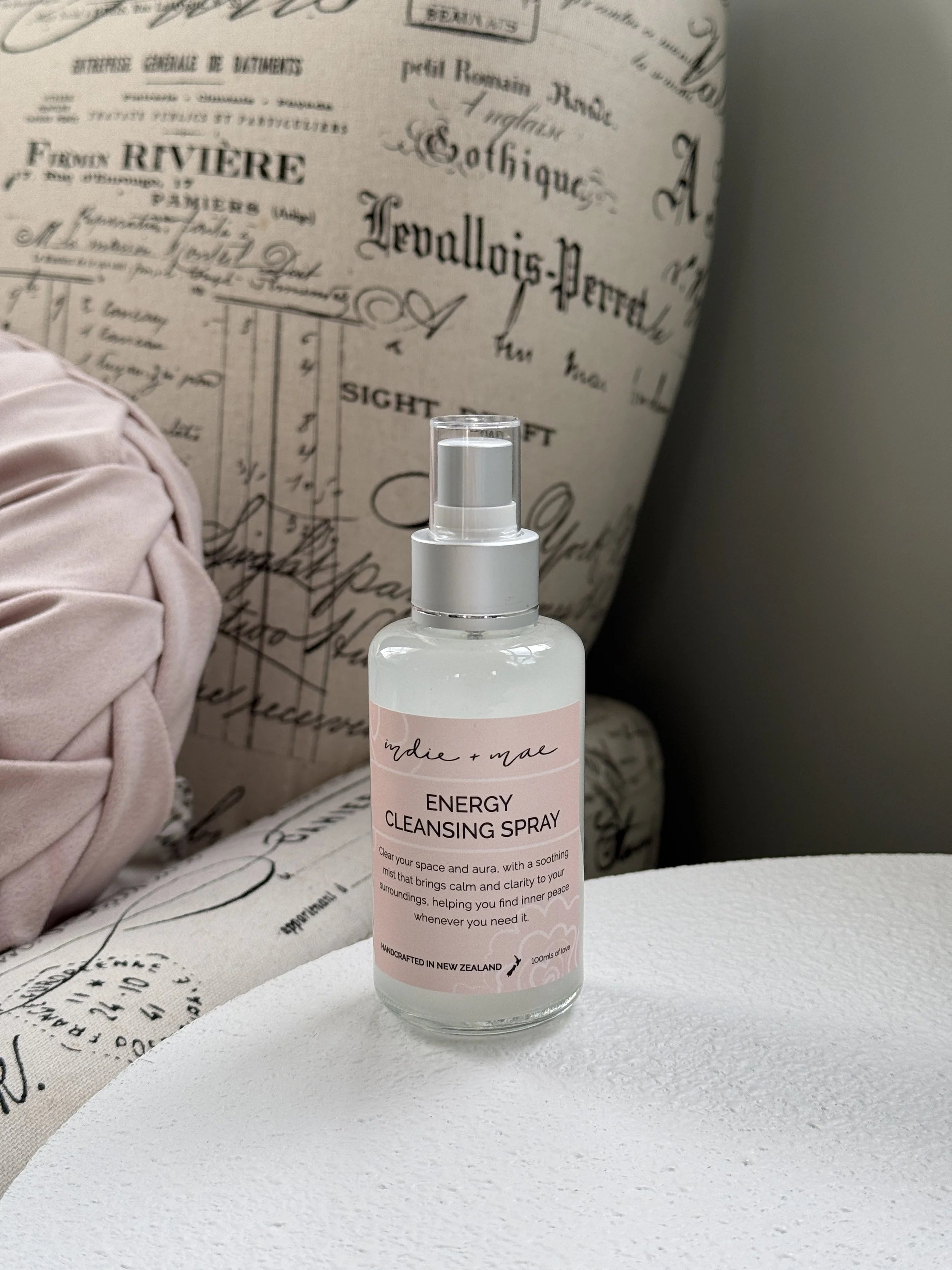 The Energy Cleansing Spray from Indie and Mae sitting on a white side table