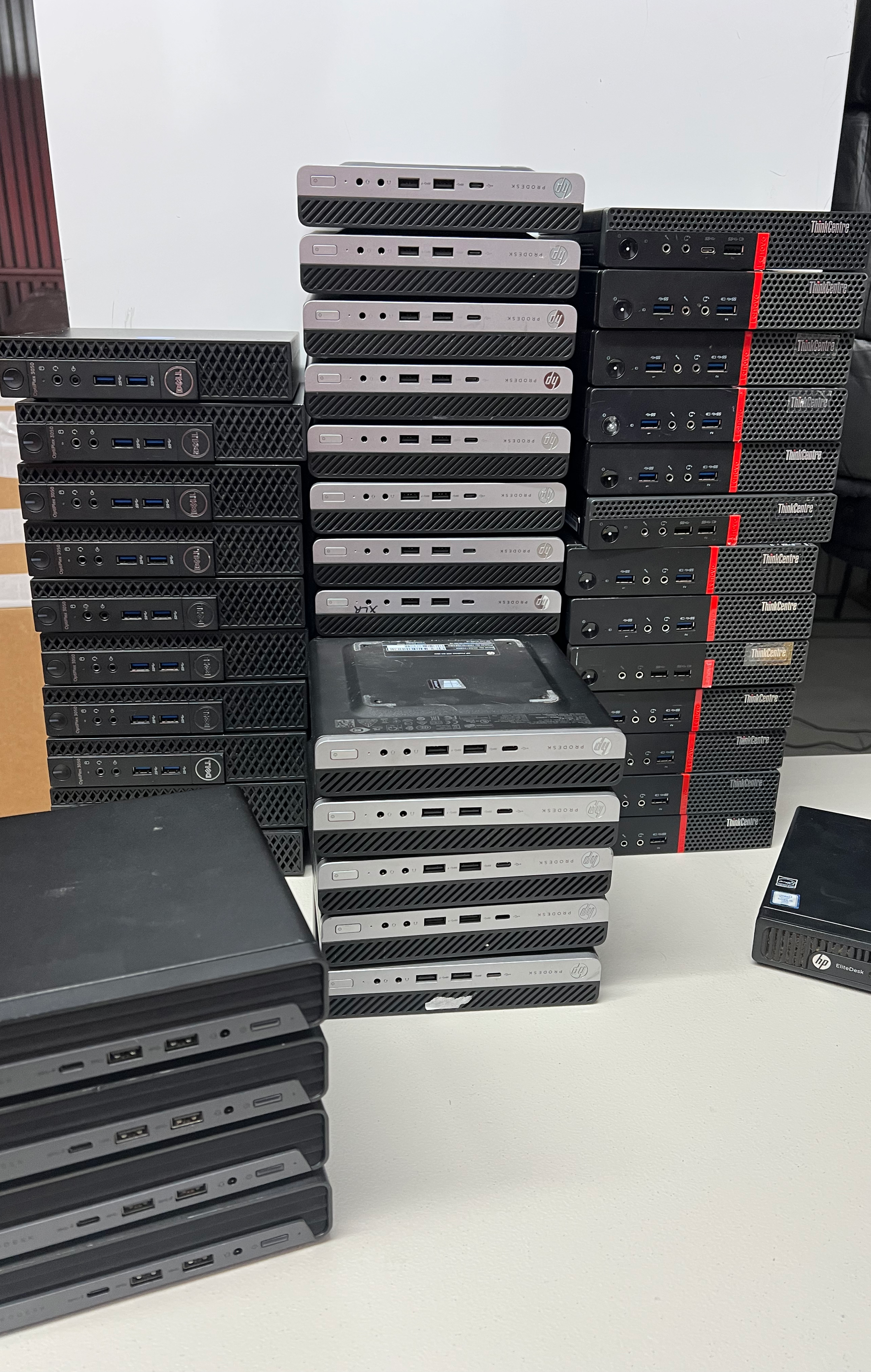 Stack of refurbished desktop computers prepared for resale and bulk sale