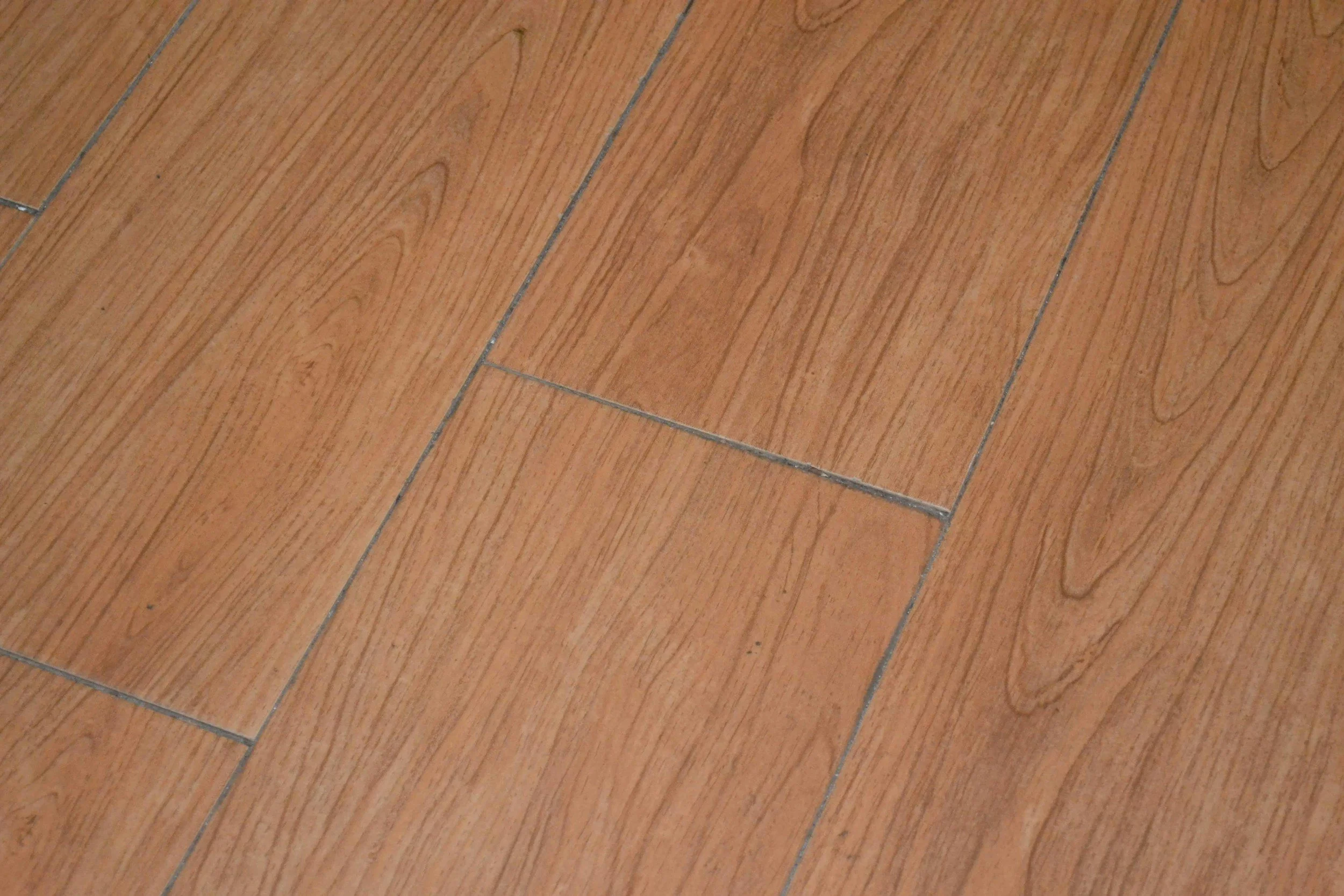 Close-up photo of wooden laminate flooring with rectangular planks arranged in a staggered pattern.