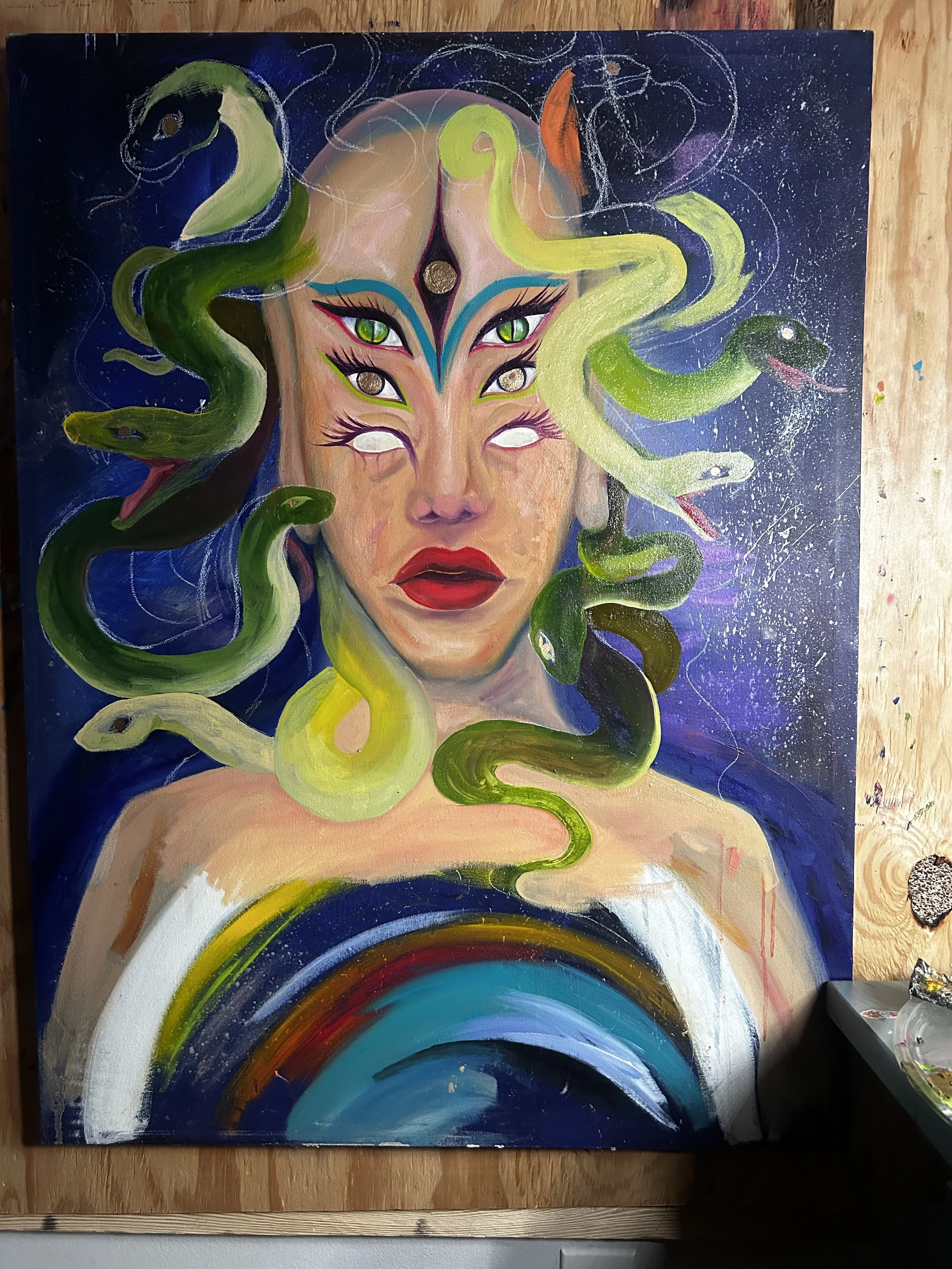 A surreal painting of a woman with snake-like hair, multiple eyes, and a rainbow below her shoulders. The background is dark with star-like splatters.