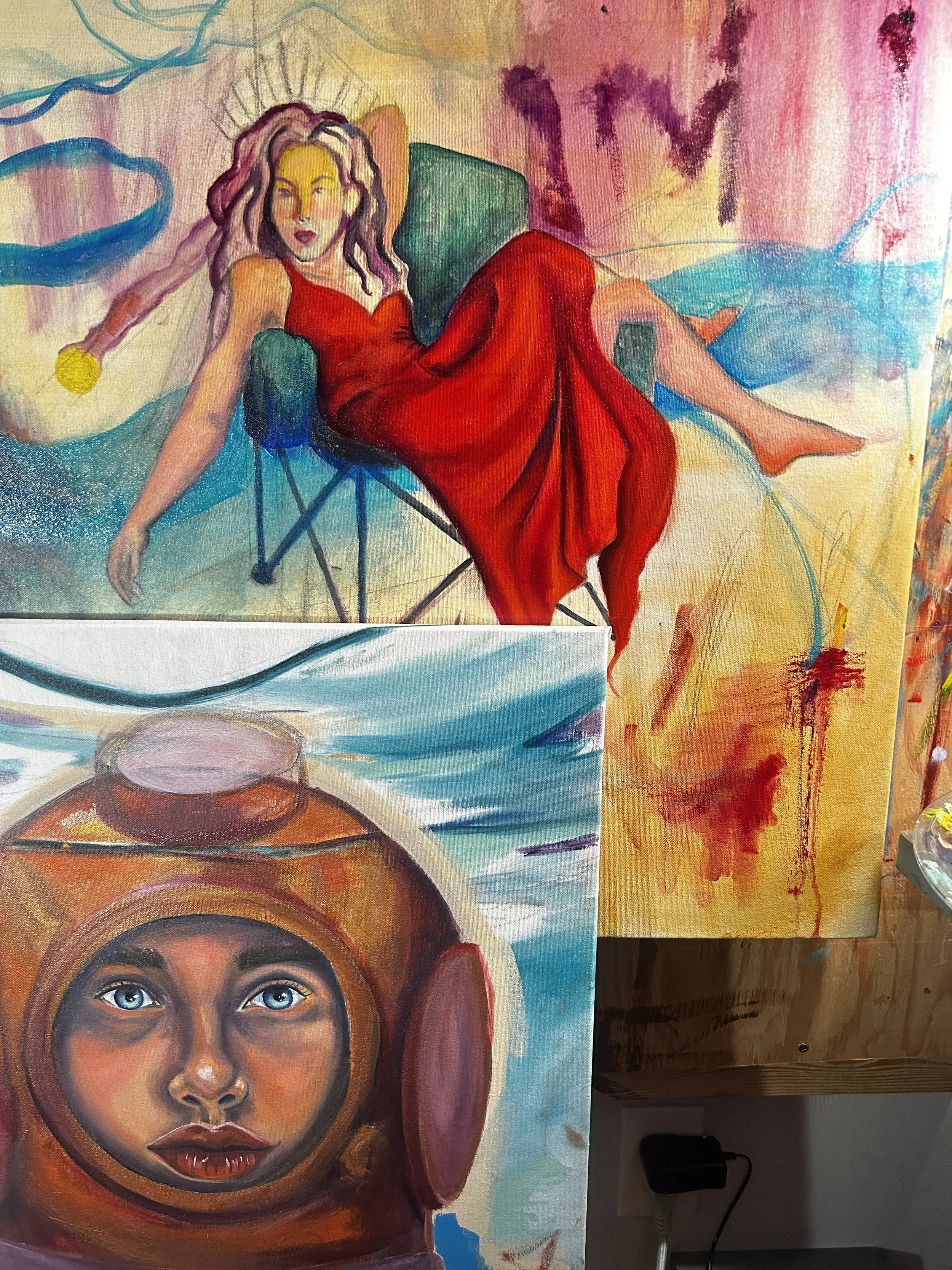 Colorful paintings featuring a woman in a red dress lounging on a green chair with flowing hair, and a woman with blue eyes wearing a space helmet, set against expressive, abstract backgrounds.