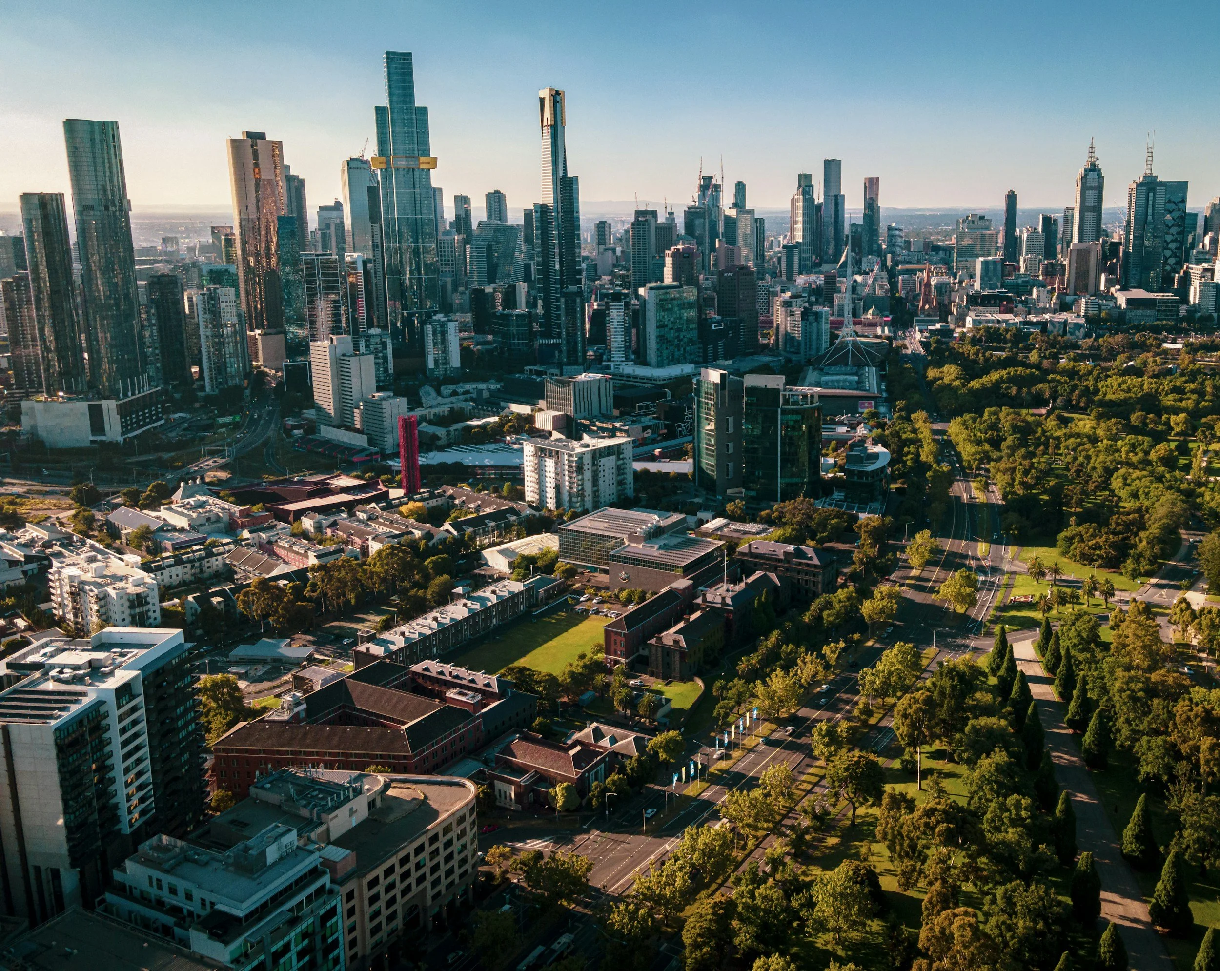 Aerial view of a city skyline with skyscrapers and green parks during daytime.