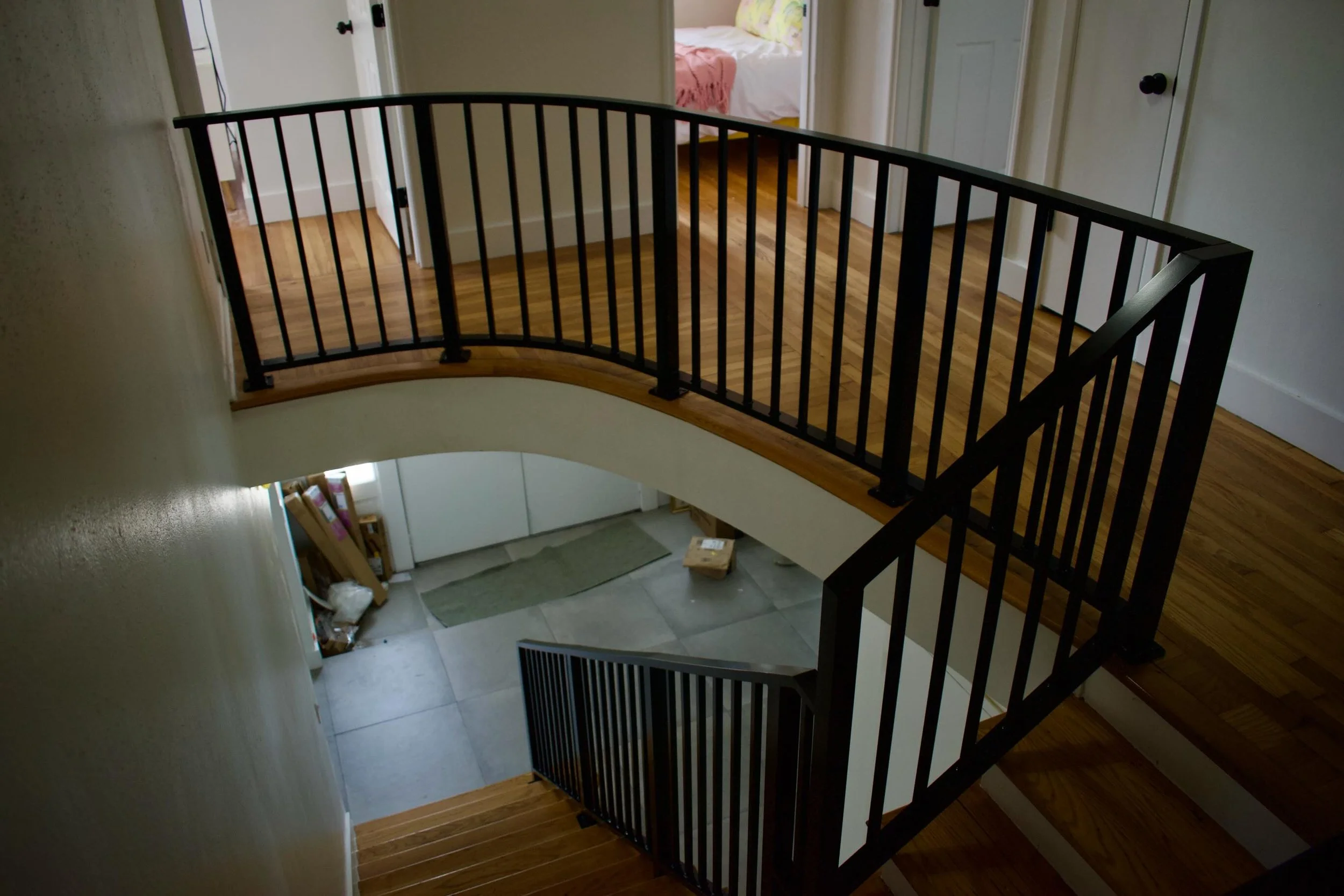 TIG welded aluminum railing featuring vertical pickets and satin black powder coat. The curved section connects from the second story landing to the stairs below for one clean continuous run.

#custommetalwork #aluminumrailing #interiordesign #stairc