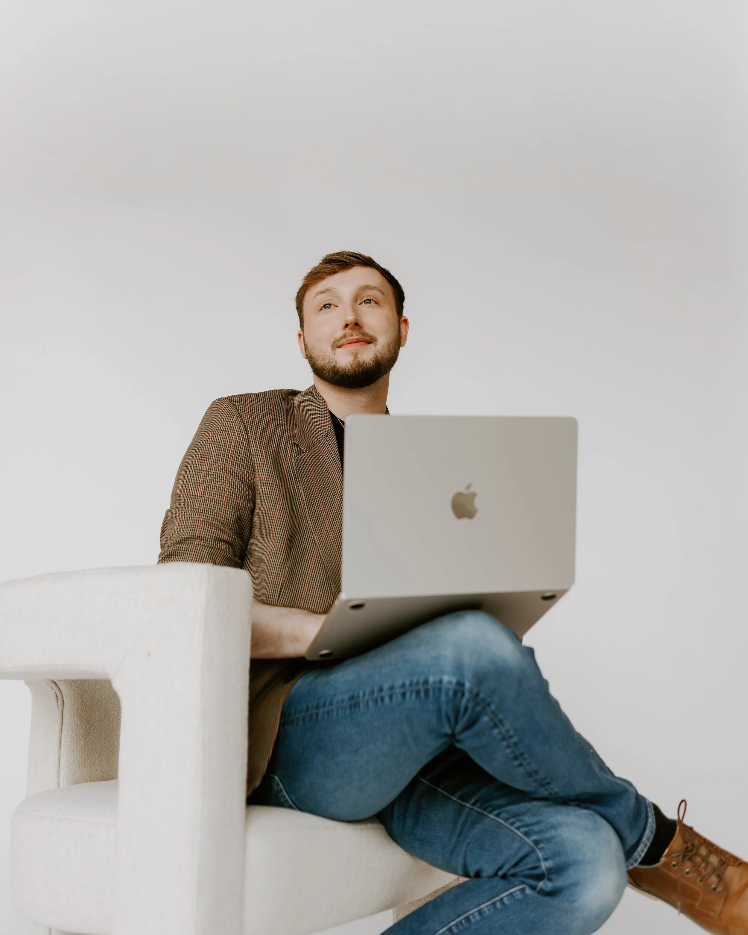William Randall working on a laptop while seated in a studio setting.