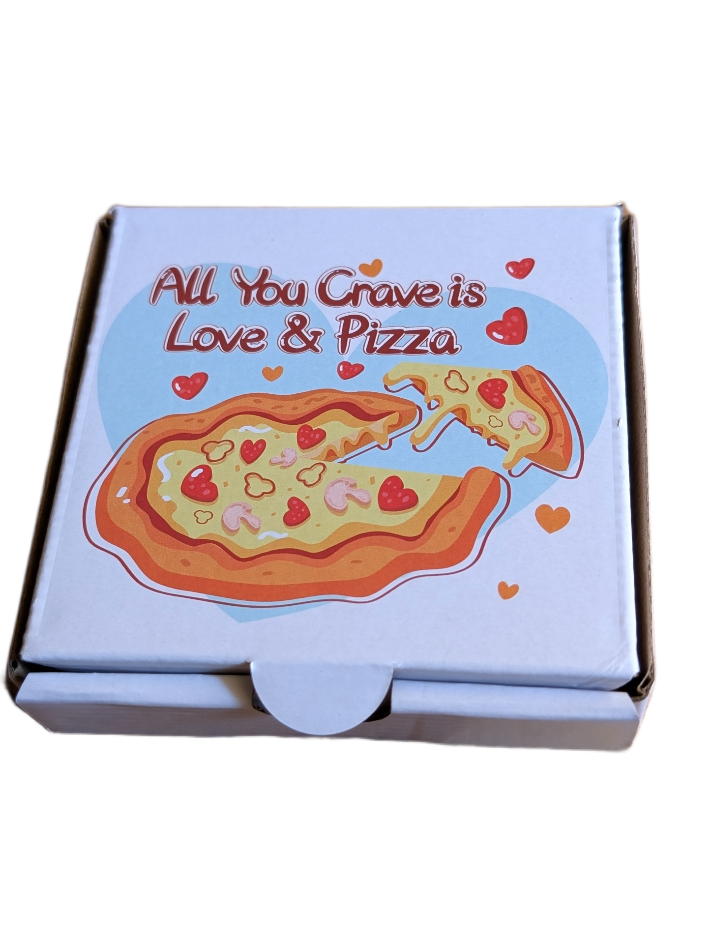 Pizza box with the phrase "All You Crave is Love & Pizza" and a cartoon pizza slice with heart-shaped toppings.
