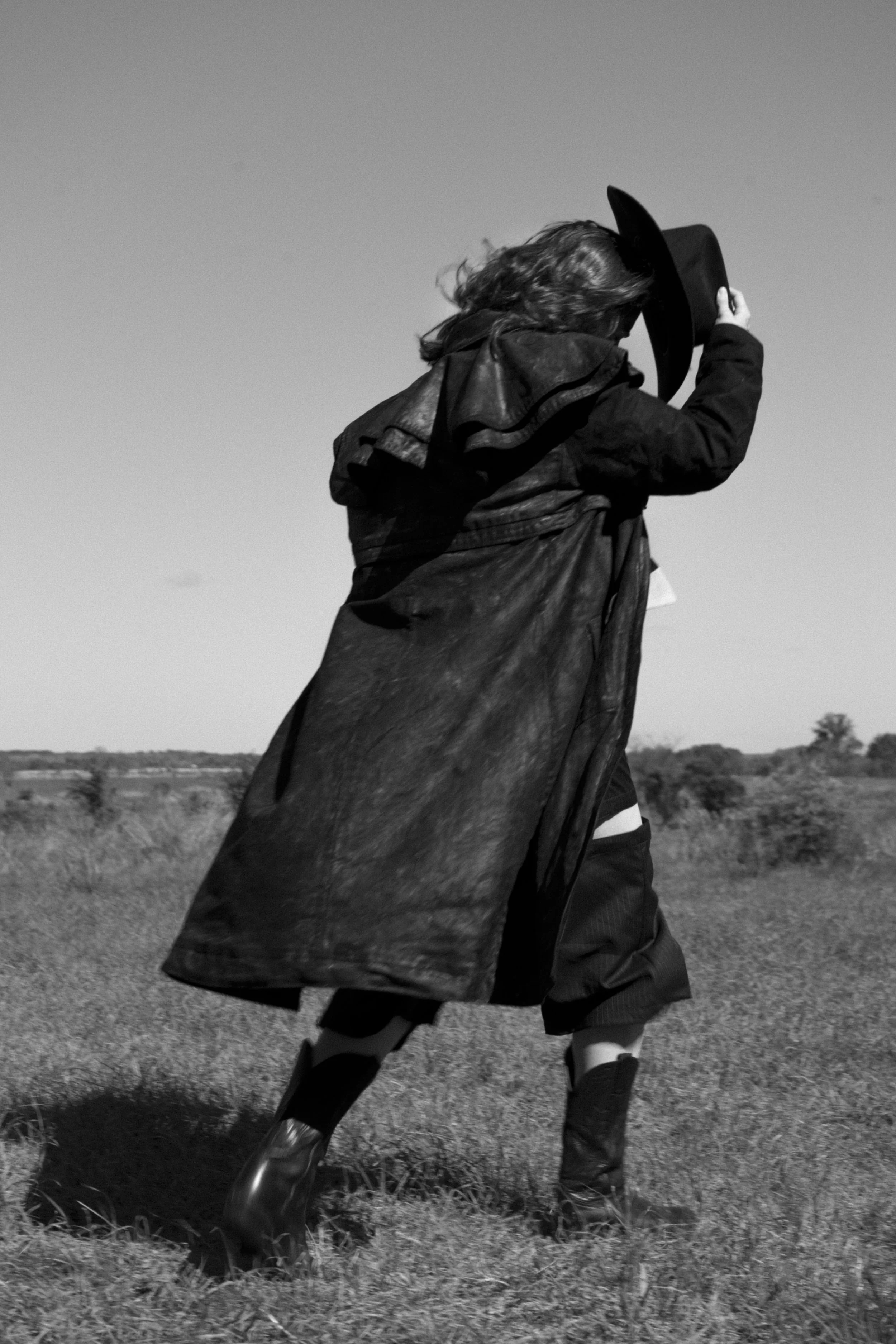 The Coat: Patterned after a classic western duster with additional cape. Blue denim airbrushed black with parafin wax treatment.