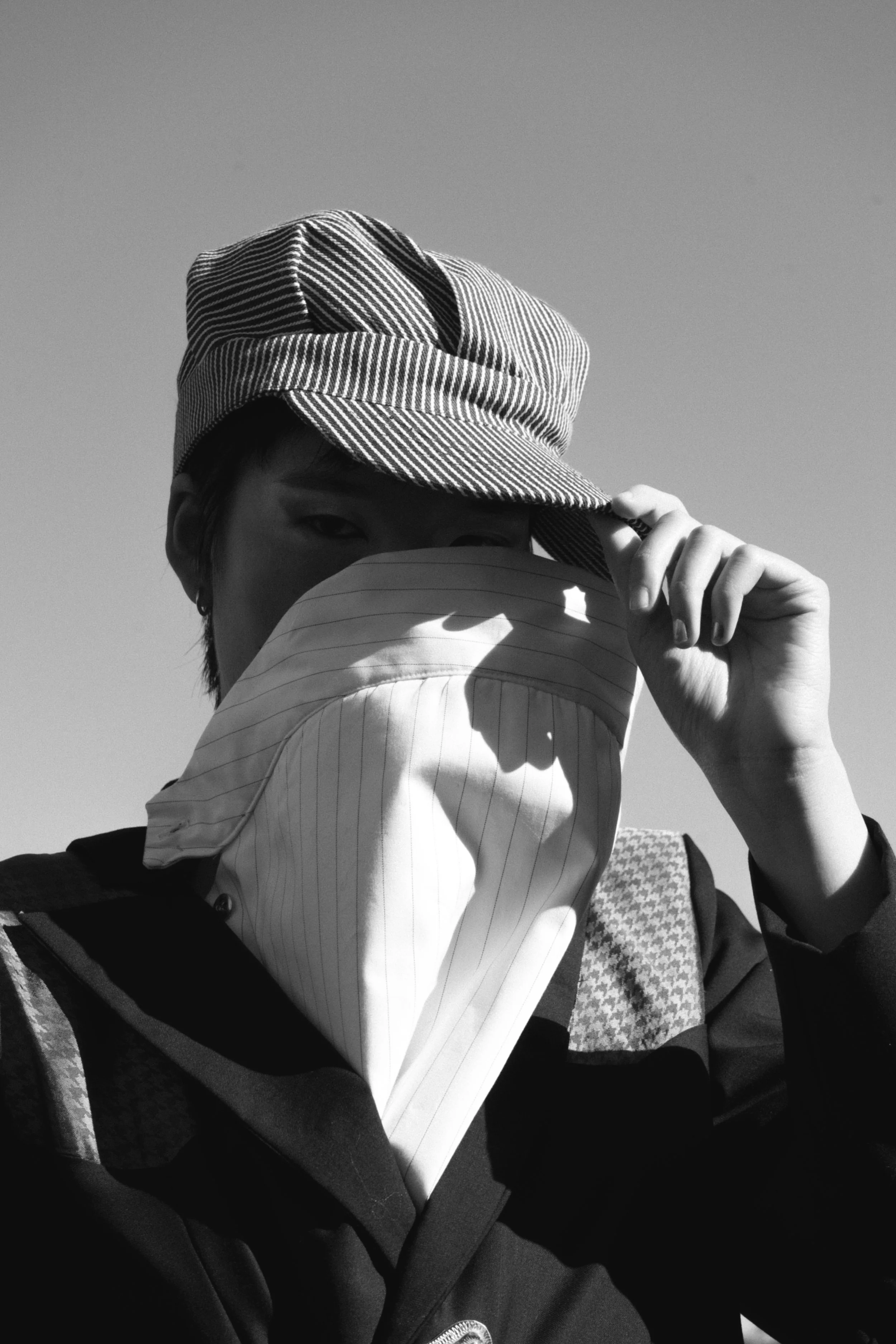 Facial cover derived from classic western bib-buttoned shirts; buttoned into inner jacket. 