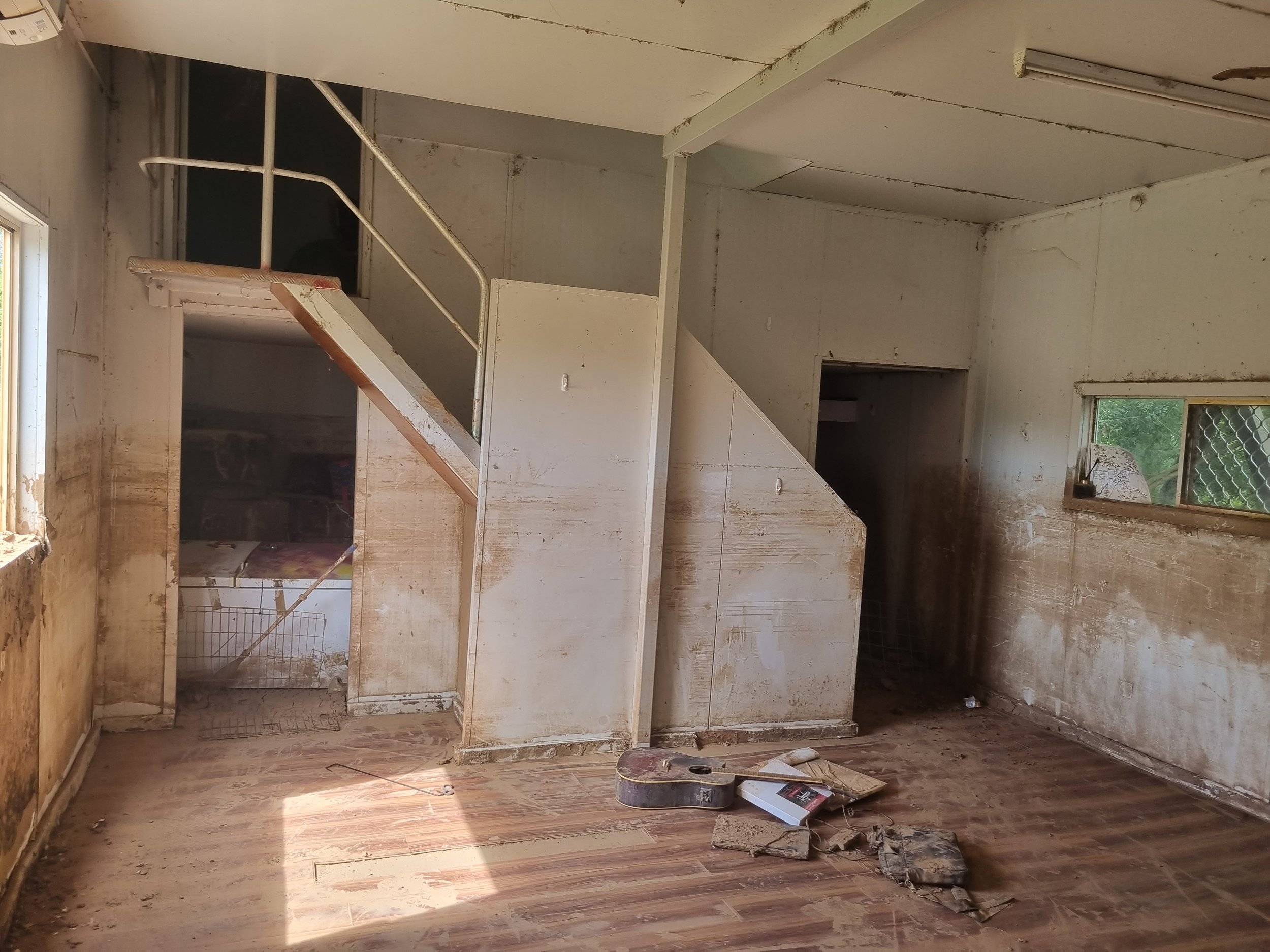 Flood-damaged interior of a Kimberley home showing mud staining on walls and floors, assessed by Cooee Constructions during a building condition inspection