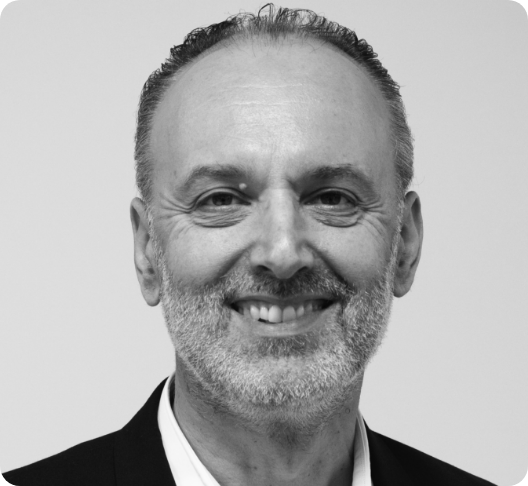 Black-and-white portrait of a smiling middle-aged man with short hair, a beard, and wearing a suit and tie.