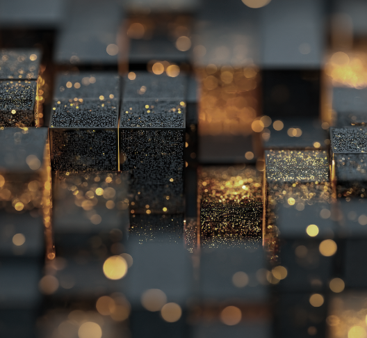 Close-up of metallic cubes with golden and black surfaces, reflecting light and creating a bokeh effect.