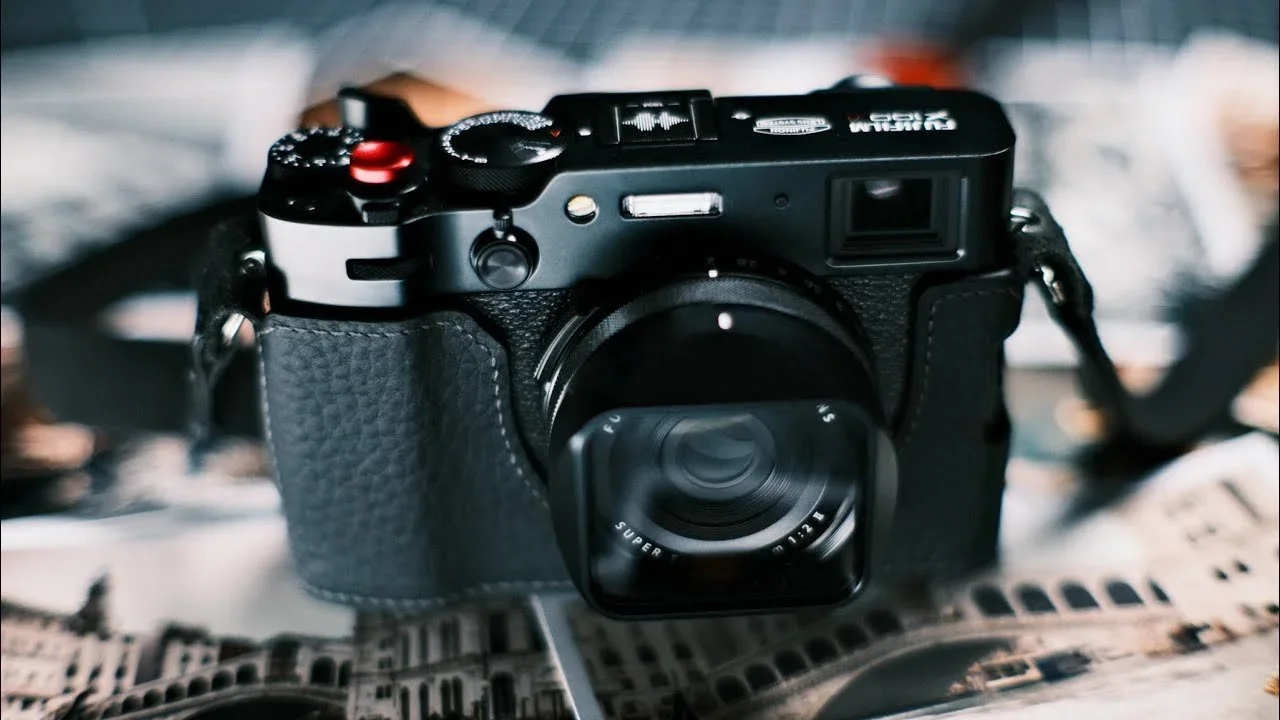 A black digital camera with a textured grip resting on an opened magazine.