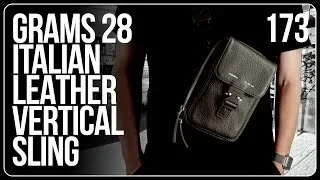 A person holding an Italian leather vertical sling bag, with text highlighting its features.