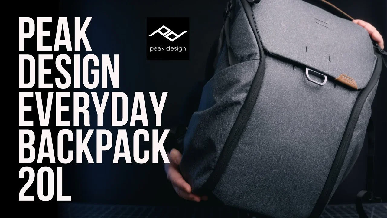 A person holding a gray backpack with a front pocket and handle, with large white text on a dark background that says "Peak Design Everyday Backpack 20L" and a black logo of peak design.