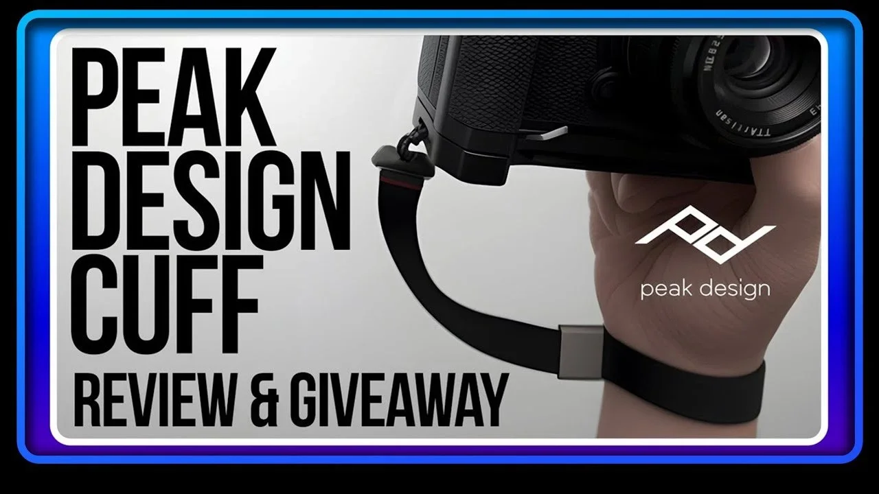 Close-up of a person holding a camera with a Peak Design camera strap in a review and giveaway video thumbnail.
