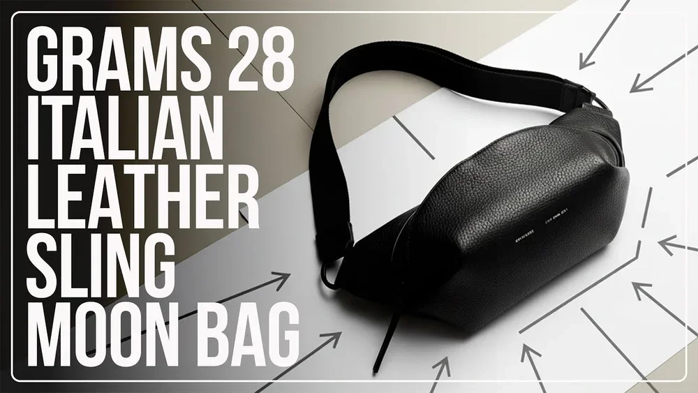 Black leather sling moon bag with an adjustable strap on a flat surface with labeled arrows highlighting its features.