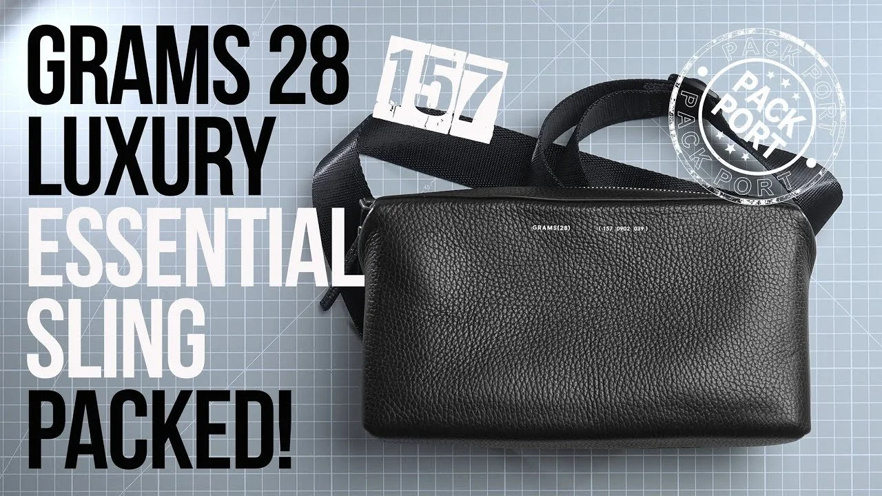 Black luxury sling bag with adjustable strap on a blue grid background, featuring white and black text promoting it as a compact 28 grams, essential, and luxury item.