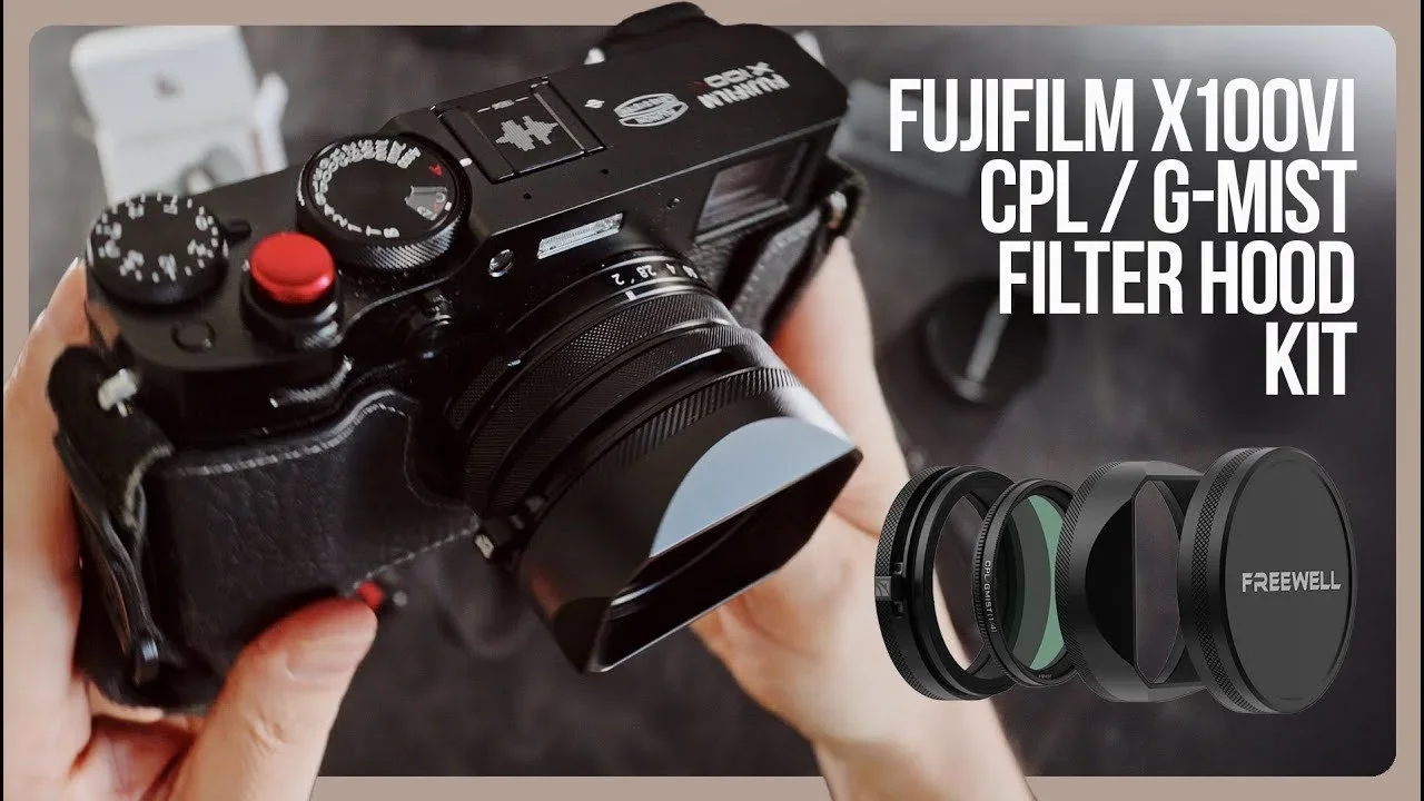 A person holding a Fujifilm X100V camera with a lens hood and filter kit displayed beside it.