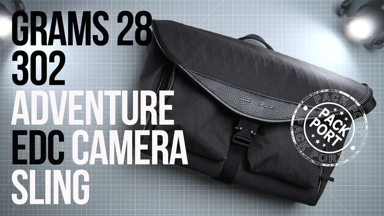 A black adventure sling bag with a strap, placed on a gray grid background with a bright spotlight. Overlaid text indicates it weighs 28 grams and 302.