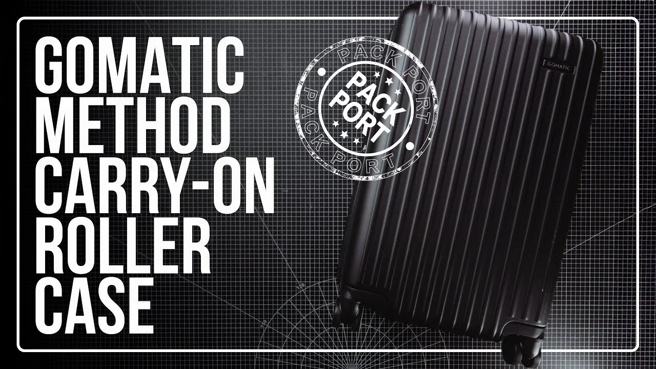 Black carry-on roller suitcase with vertical ridges on a dark grid background, featuring a stamp that says 'Pack Port'.