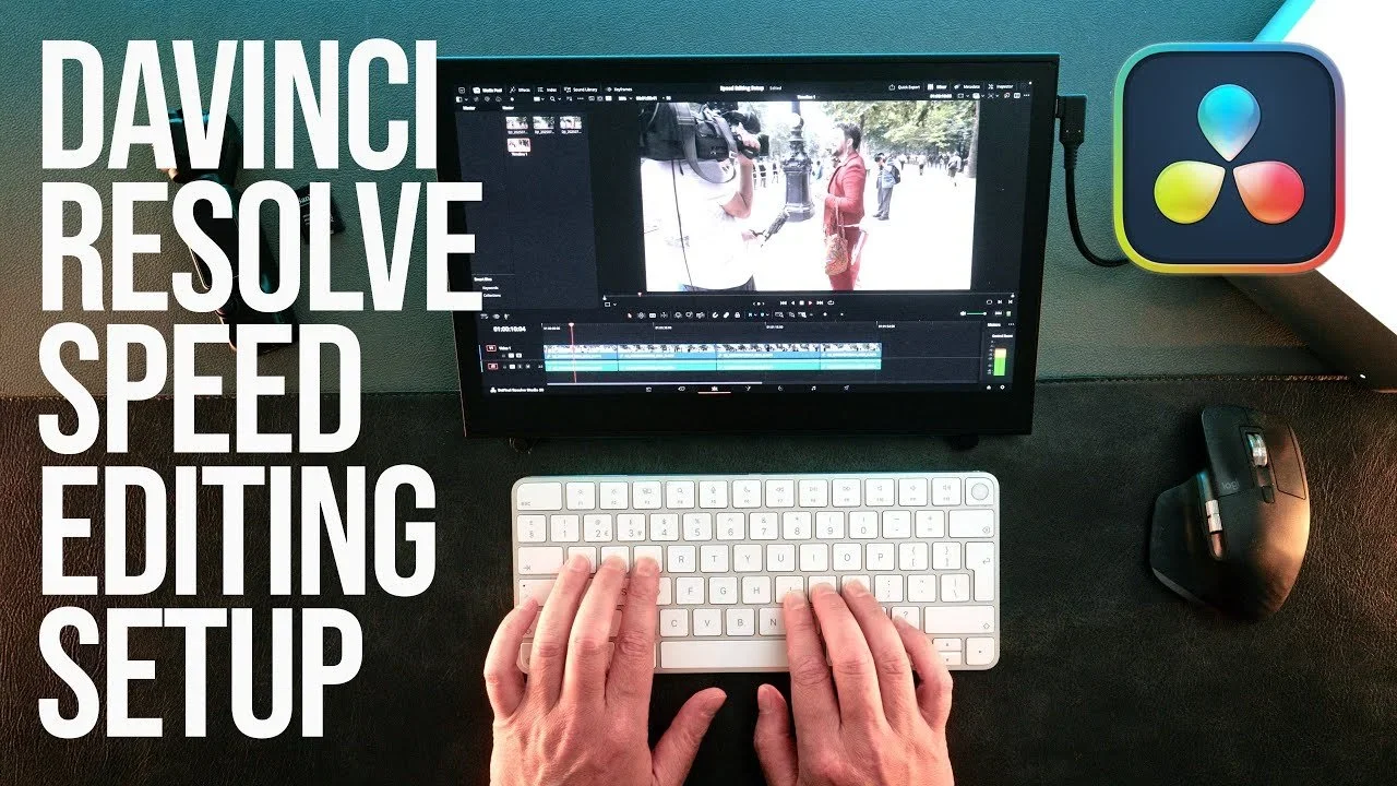 A computer monitor displaying a video editing software with footage of people in an outdoor setting. A person’s hands are typing on a white keyboard, with a wireless mouse to the right. To the left of the monitor, there are large white words saying "