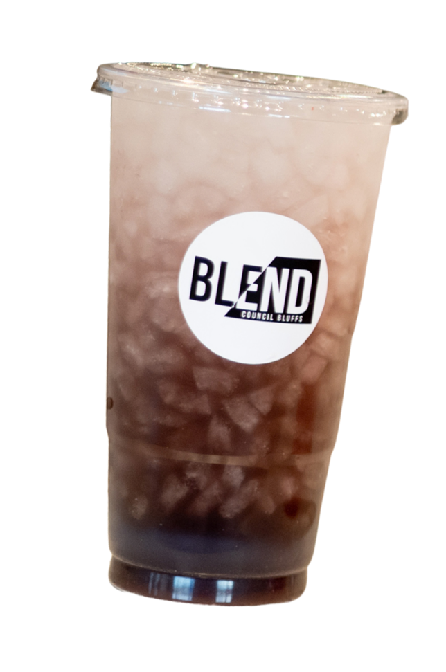 A cold, iced coffee or tea in a clear plastic cup with a black-and-white 'BLEND Council Bluffs' logo on the front.