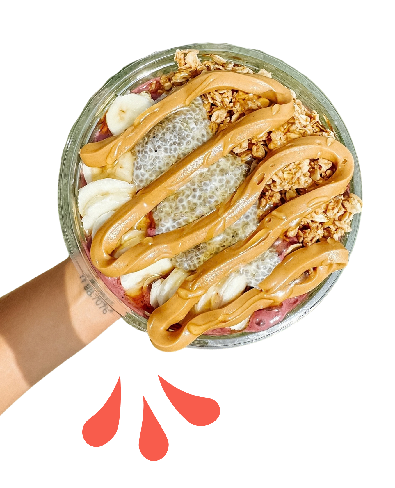A hand holding a clear bowl of layered dessert with granola, banana slices, chia pudding, vanilla pudding, and caramel drizzle, with red paint drops beneath.