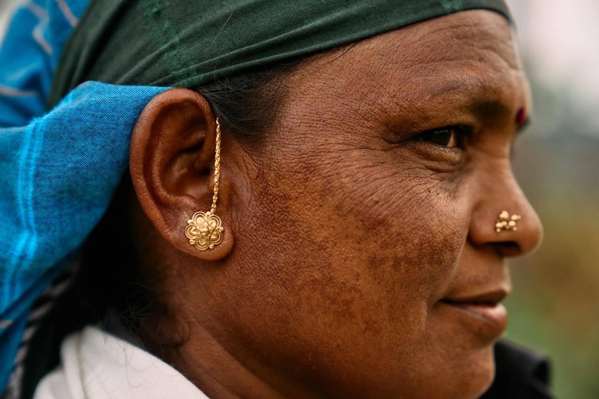 Traditional ear and nose ornament on a farmer in Tamil Nadu.