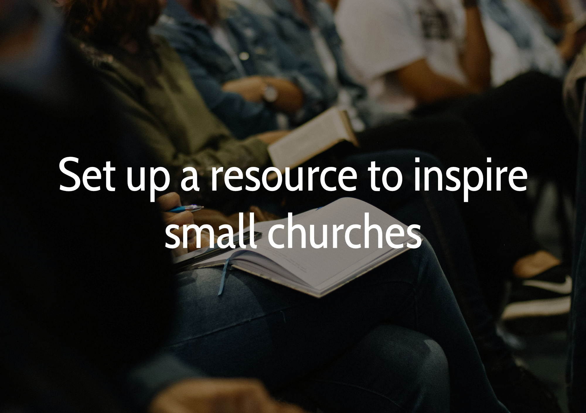 People sitting in a church, some holding notebooks and pens, during a service or event.