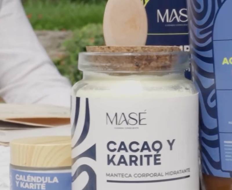 Envase con manteca corporal hidratante de cacao y karité, de la marca MASE, con otros productos similares alrededor.