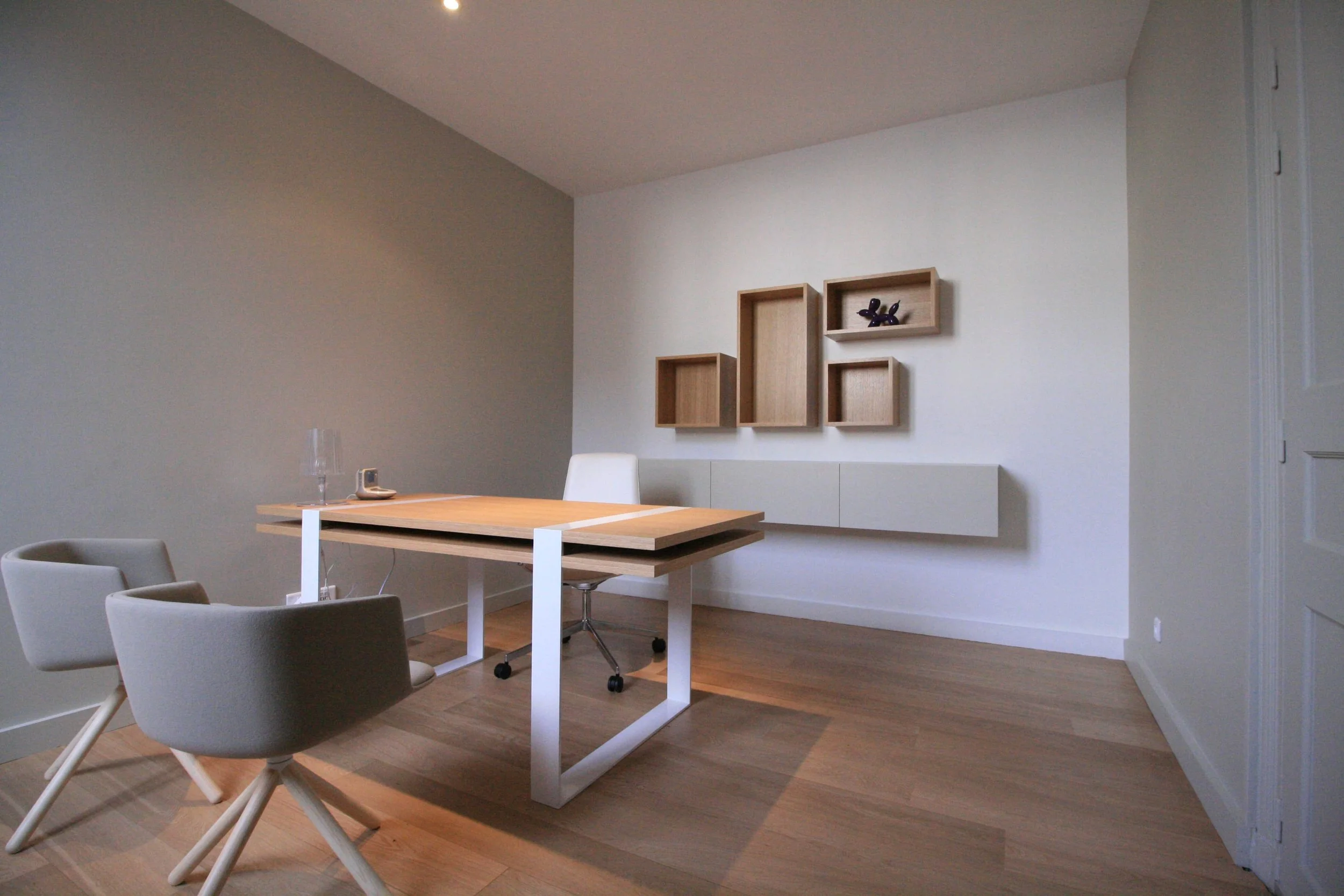 Showroom immobilier La Rochelle, architecture intérieure Niort, aménagement retail Royan, design espace conseil immobilier, mobilier bureau professionnel, cloison noire décorative, parquet chêne clair bureau
