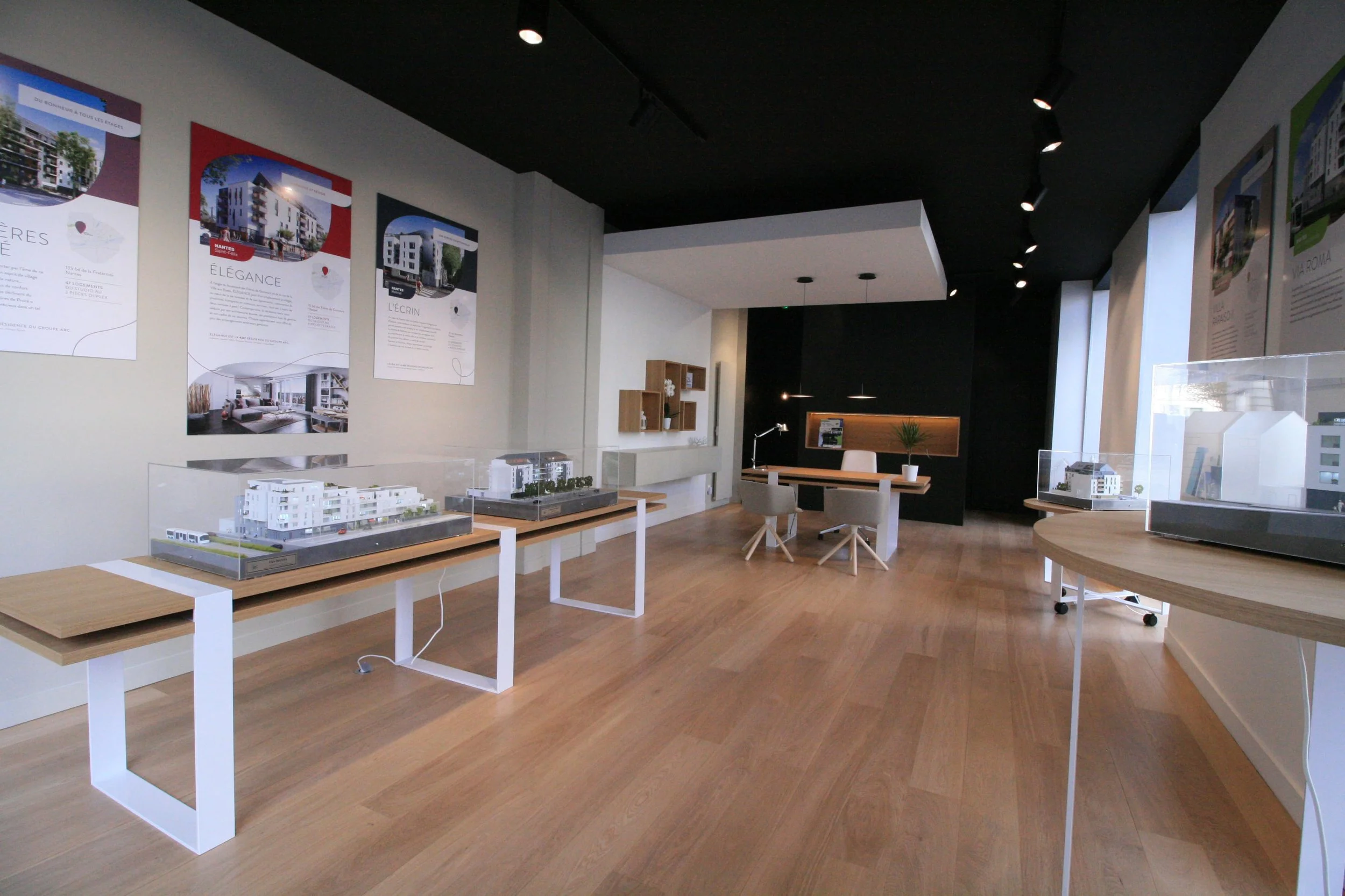 Showroom immobilier La Rochelle, architecture intérieure Niort, aménagement retail Royan, design espace conseil immobilier, mobilier bureau professionnel, cloison noire décorative, parquet chêne clair bureau
