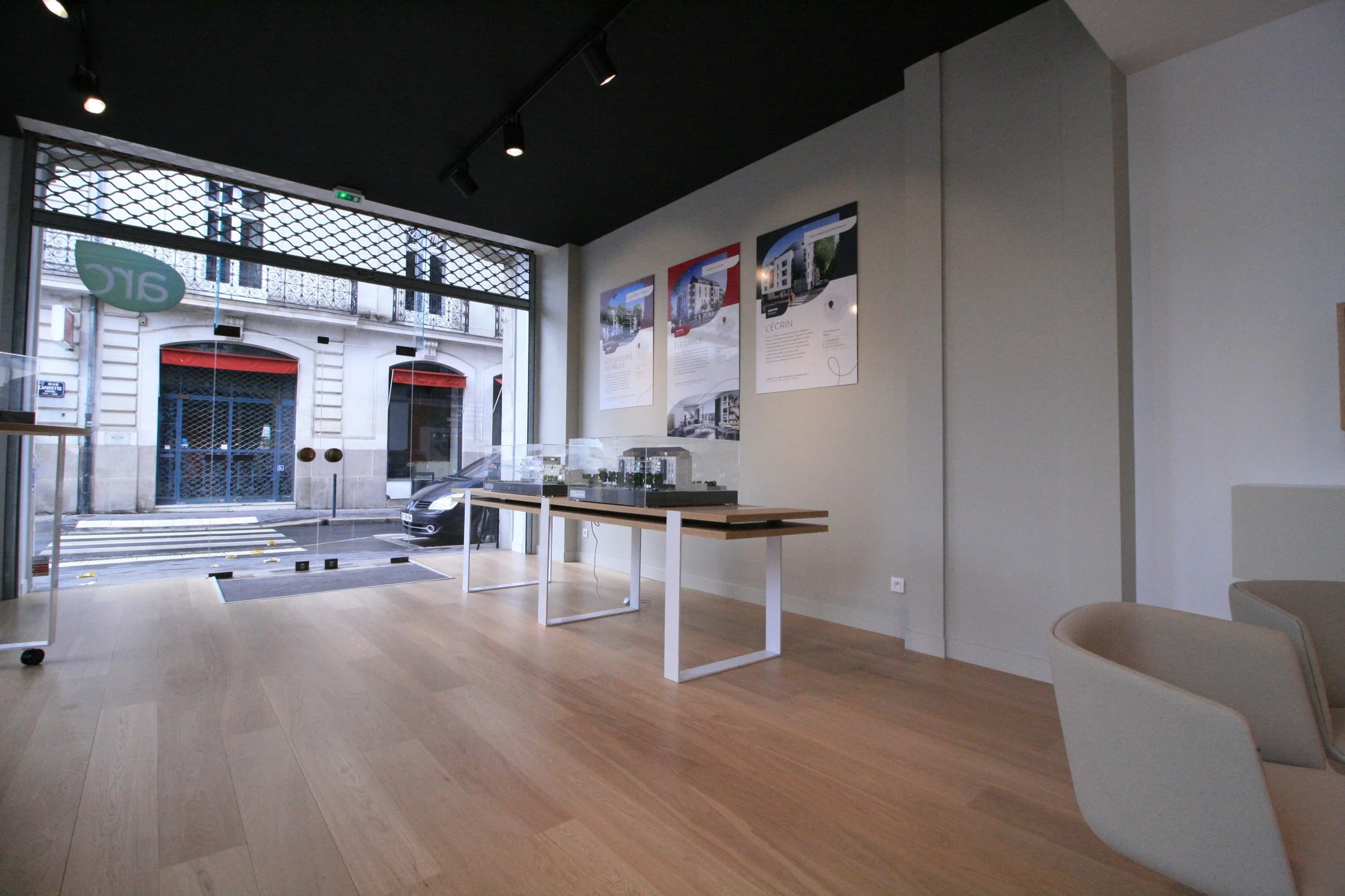 Showroom immobilier La Rochelle, architecture intérieure Niort, aménagement retail Royan, design espace conseil immobilier, mobilier bureau professionnel, cloison noire décorative, parquet chêne clair bureau