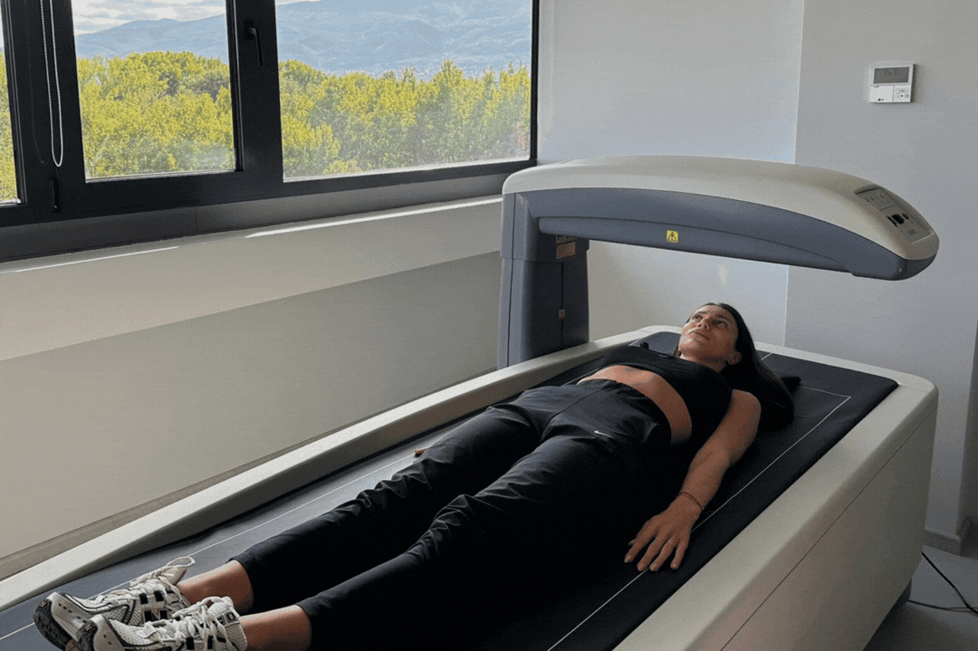 Woman performing a DEXA scan at DexaFit Sofia, Bulgaria with text overlay showing metrics and data like left leg lean mass trunk lean mass  and arms total fat