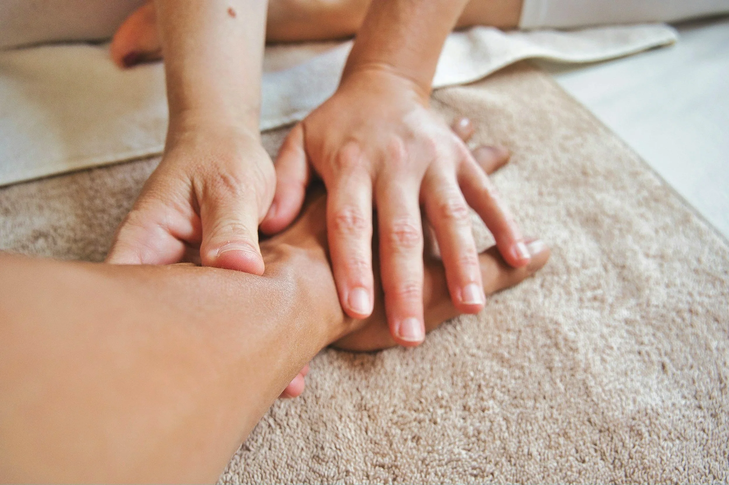 Une personne reçoit un massage du dos sur une table en utilisant ses mains.
