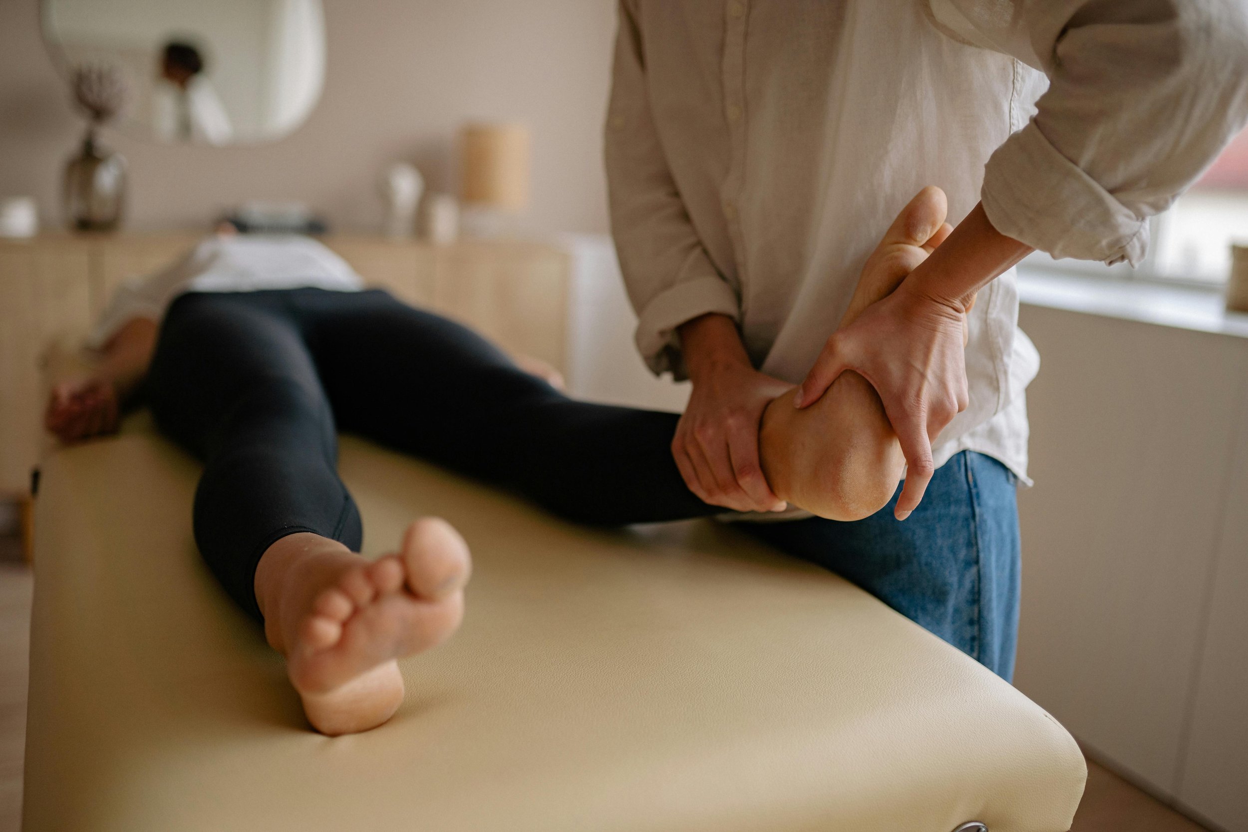 Une personne reçoit une thérapie de massage du pied dans une salle de soins.