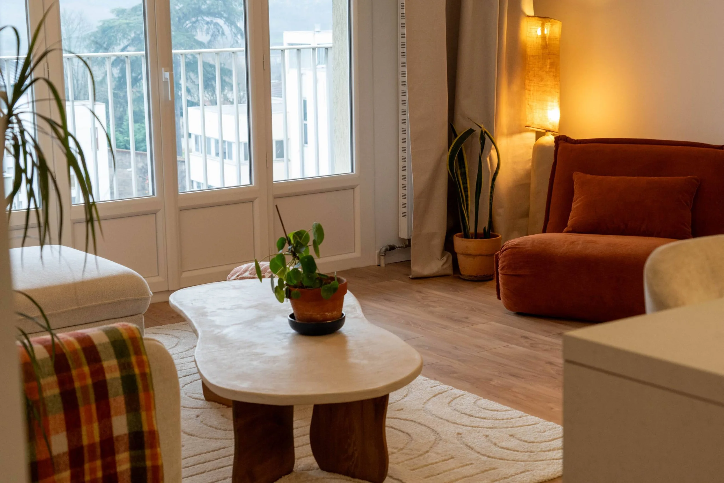 Table basse : une planche récupérée en début de chantier travaillée en forme organique et recouverte de colle à carrelage et de brou de noix.