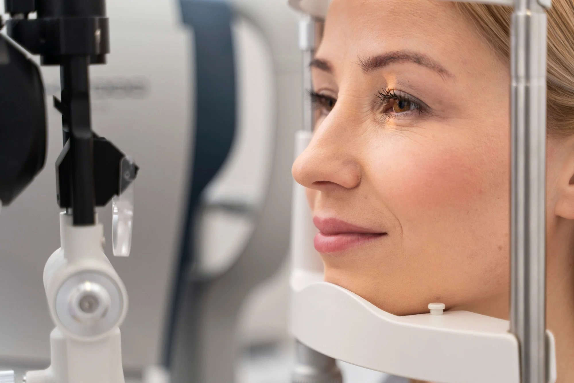 A woman undergoing an eye examination using a specialized medical device.