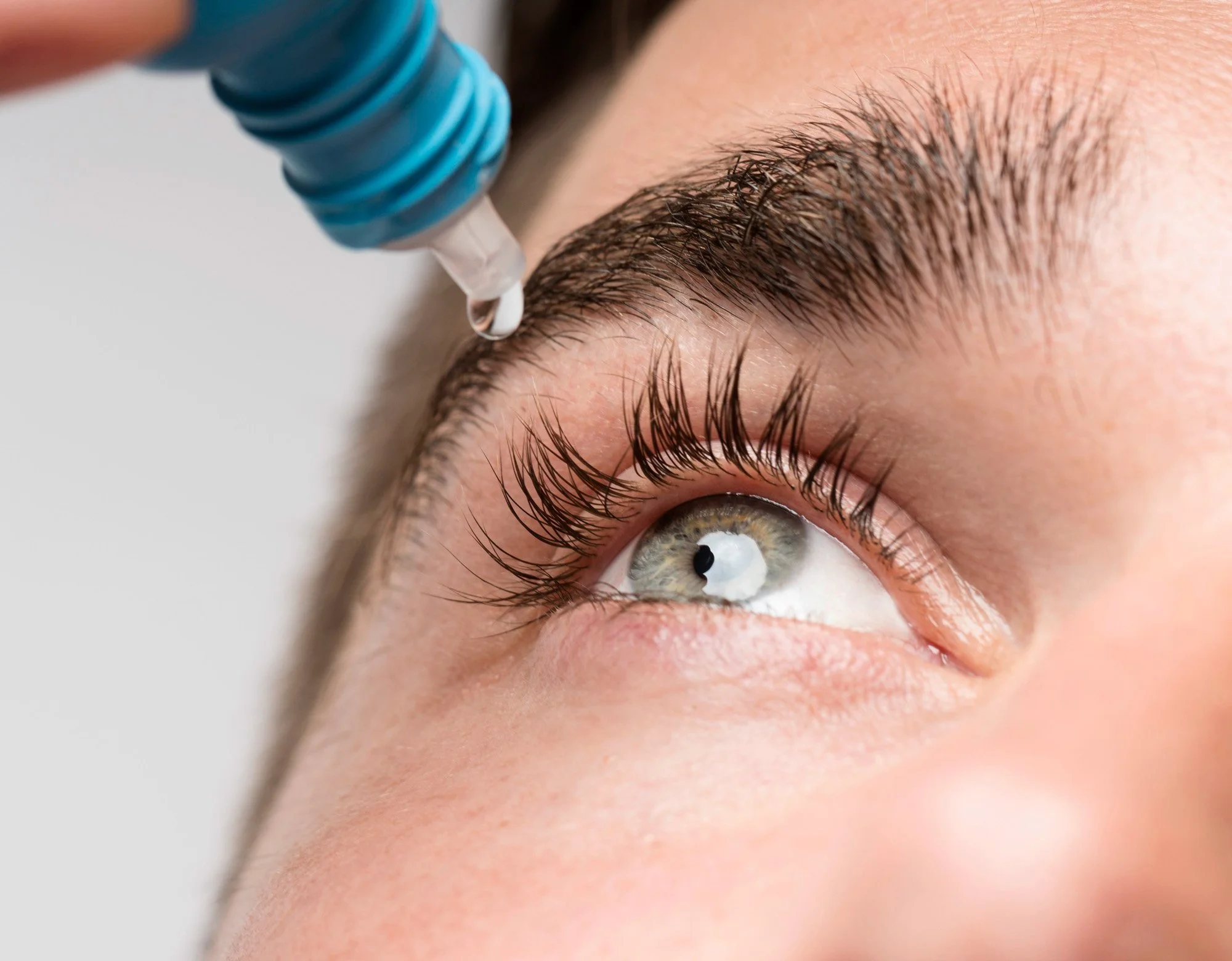 Close-up of a person receiving a cosmetic injection near their eyebrow.