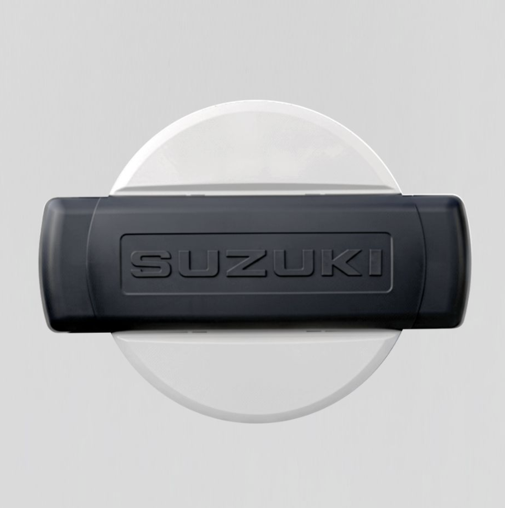 Close-up of a black Suzuki car key fob with the Suzuki logo embossed on it, placed on a white surface.