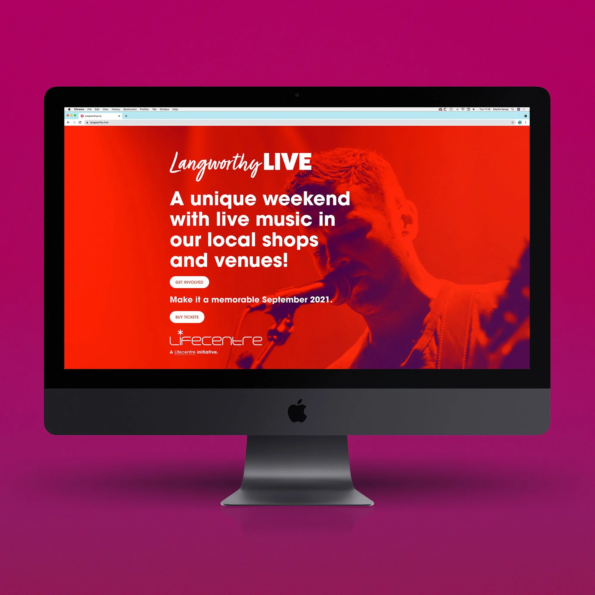 An iMac computer displaying a promotional webpage for Langworthy Live, an event featuring live music at local shops and venues scheduled for September 2021, with a background of a person singing into a microphone.