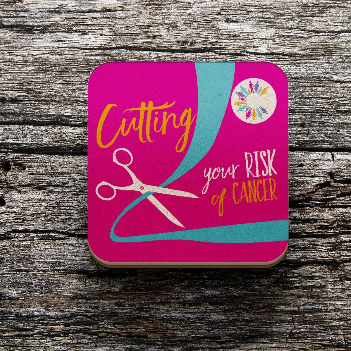Colorful square with pink background and teal accents, featuring a pair of white scissors and the text 'Cutting your RISK of CANCER' in yellow and white, and a circular logo with multicolored human figures holding hands.