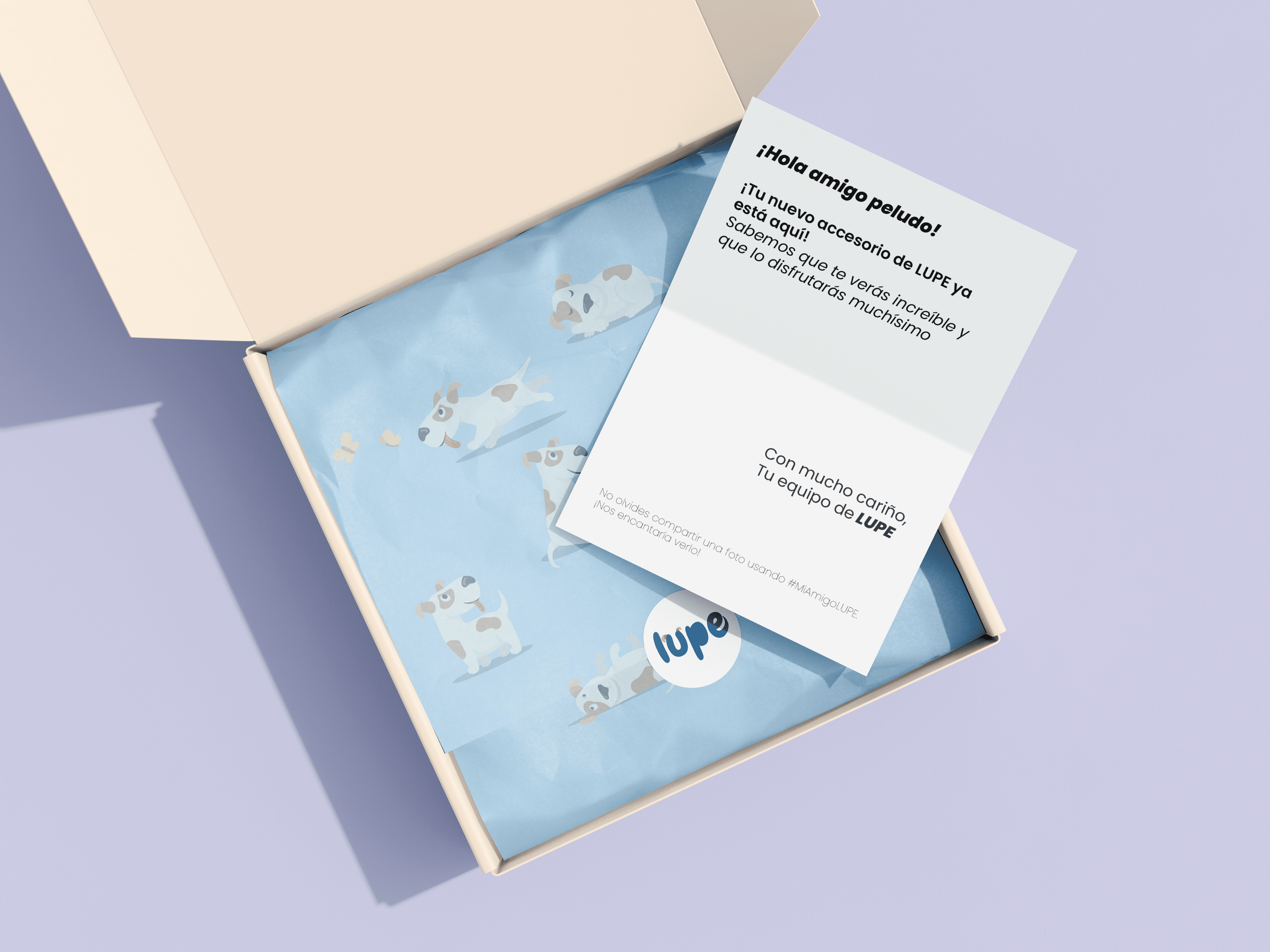 Caja de regalo con papel decorativo de perros y una carta que dice hola amigo peludo, felicitaciones por un nuevo accesorio de LUPE y muchas gracias por tu cariño, firmada por el equipo de LUPE